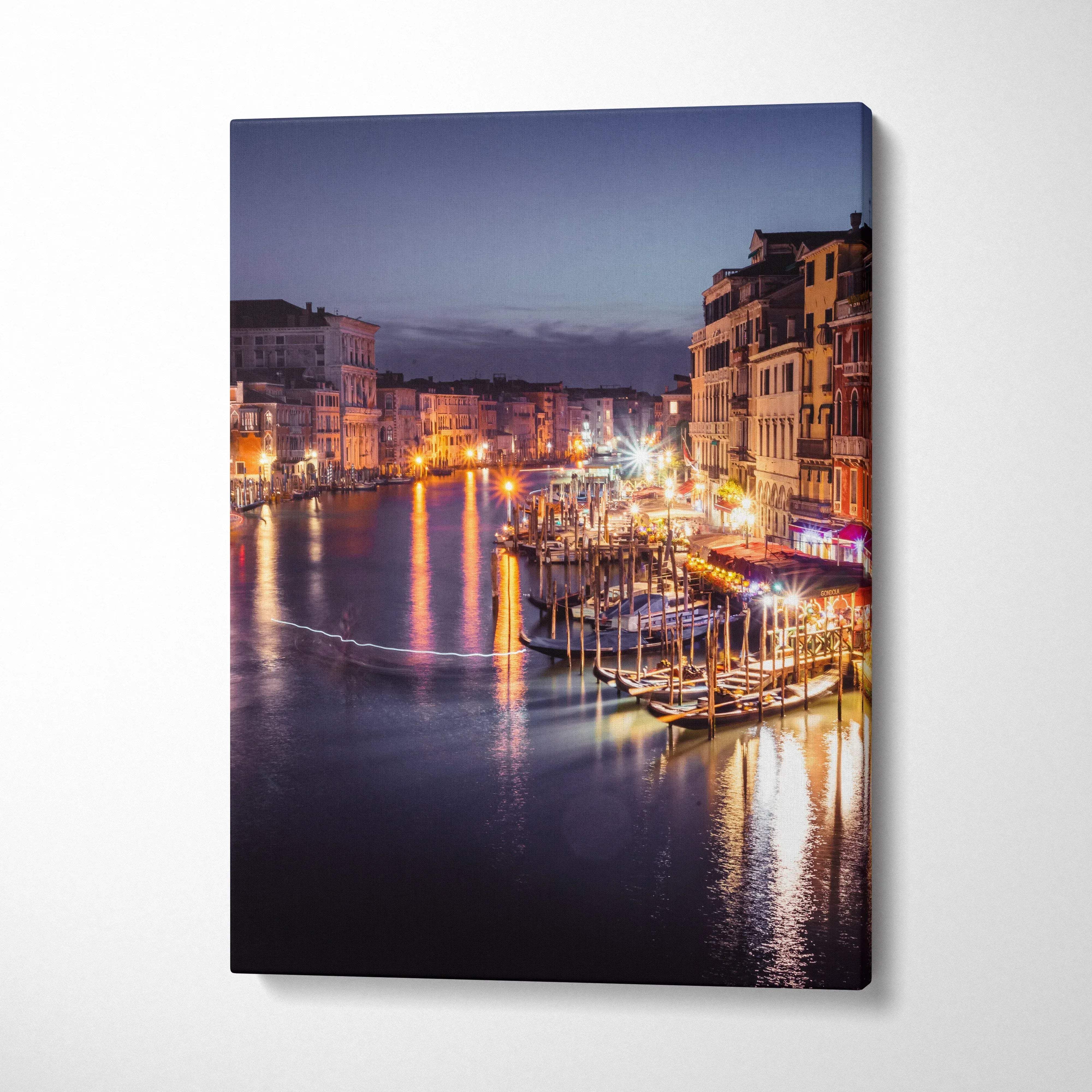 Canvas wall art featuring a luminous urban waterfront scene with buildings and glowing night reflections.