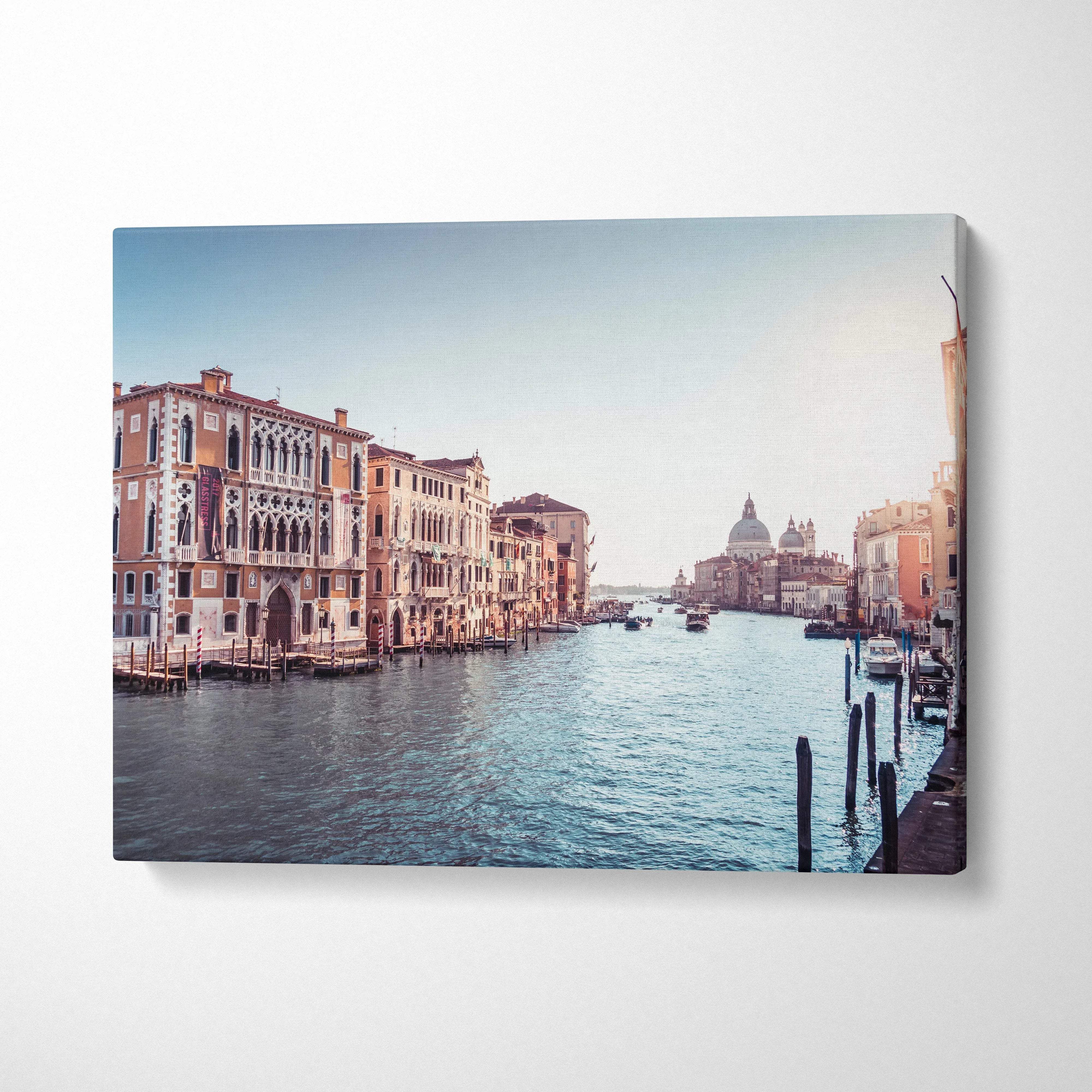 Horizontal canvas wall art featuring a serene canal scene with classic Venetian buildings and soft blue sky.