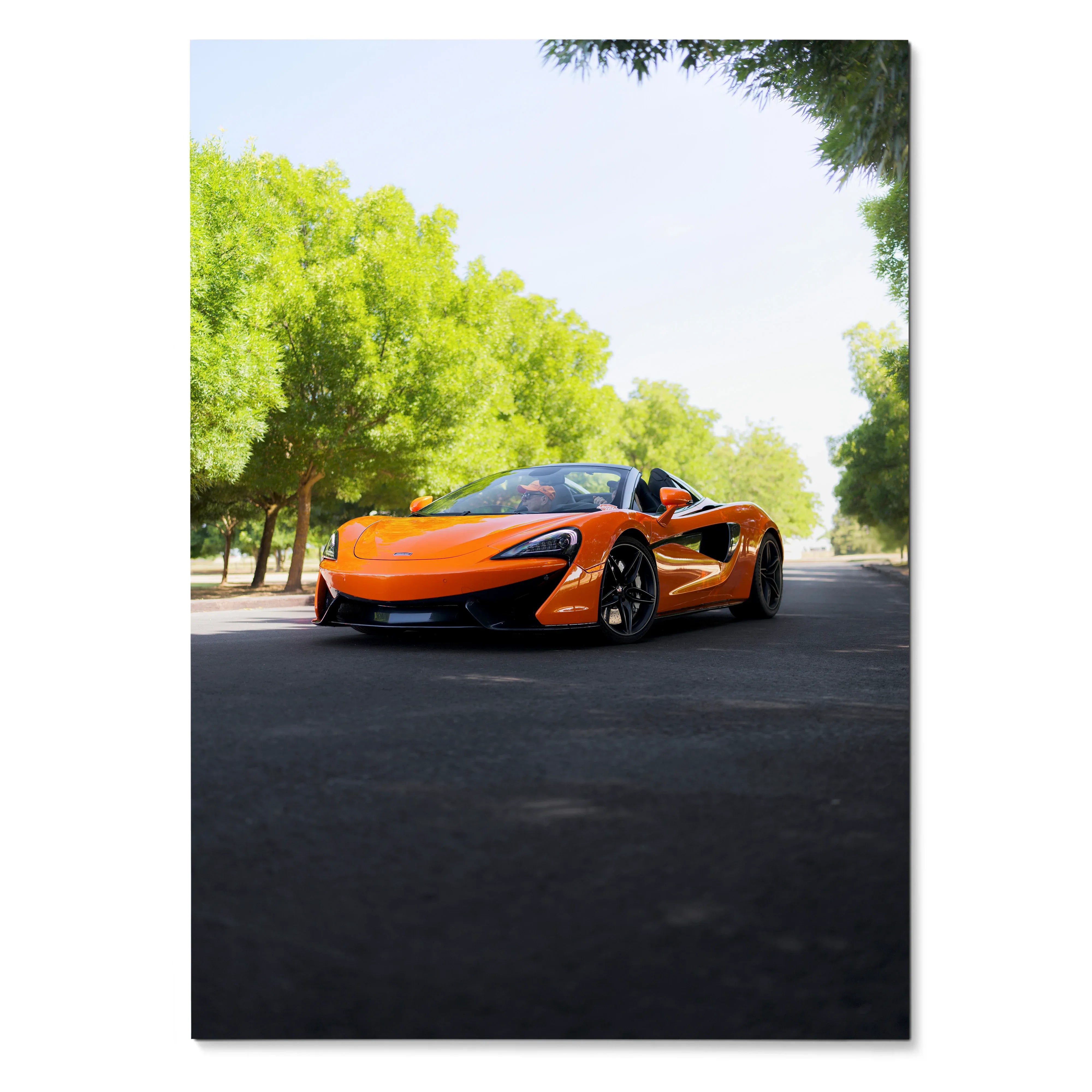 McLaren 570S in bright orange parked on asphalt with green trees, poster wall art.
