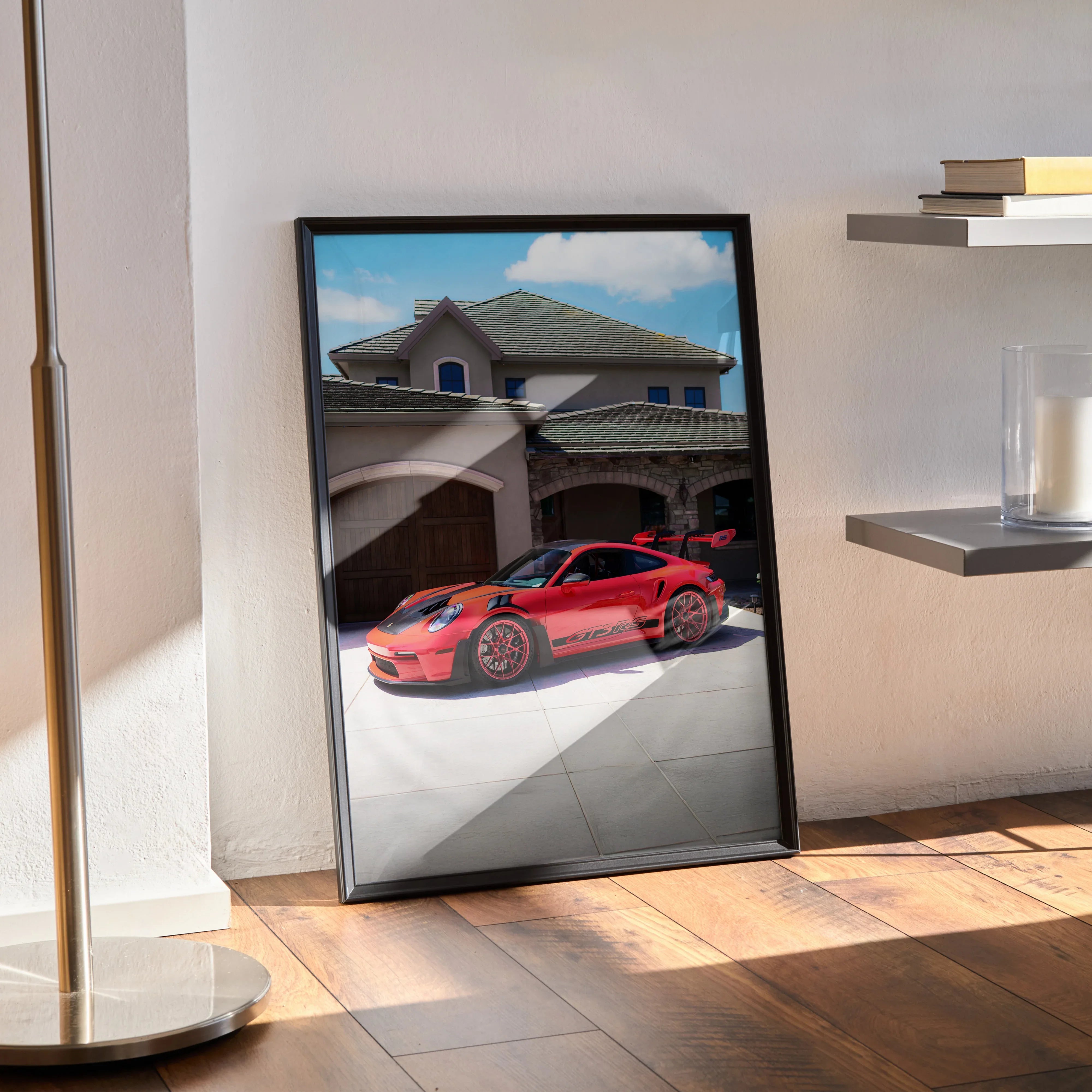 Porsche 911 GT3 RS red sports car poster framed as wall art leaning against sunlit wall.