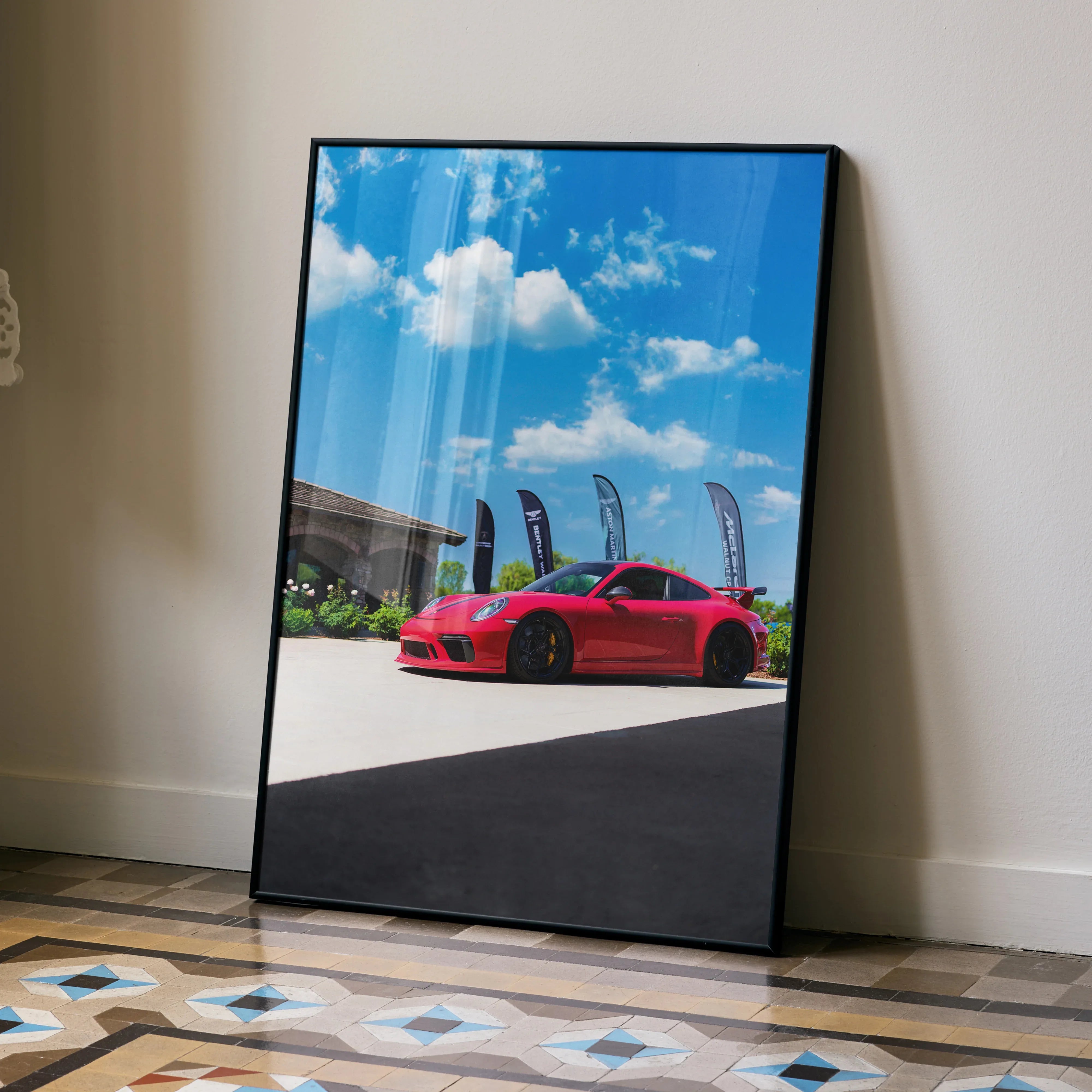 Red Porsche 911 GT3 parked outdoors under blue sky poster wall art with black frame.