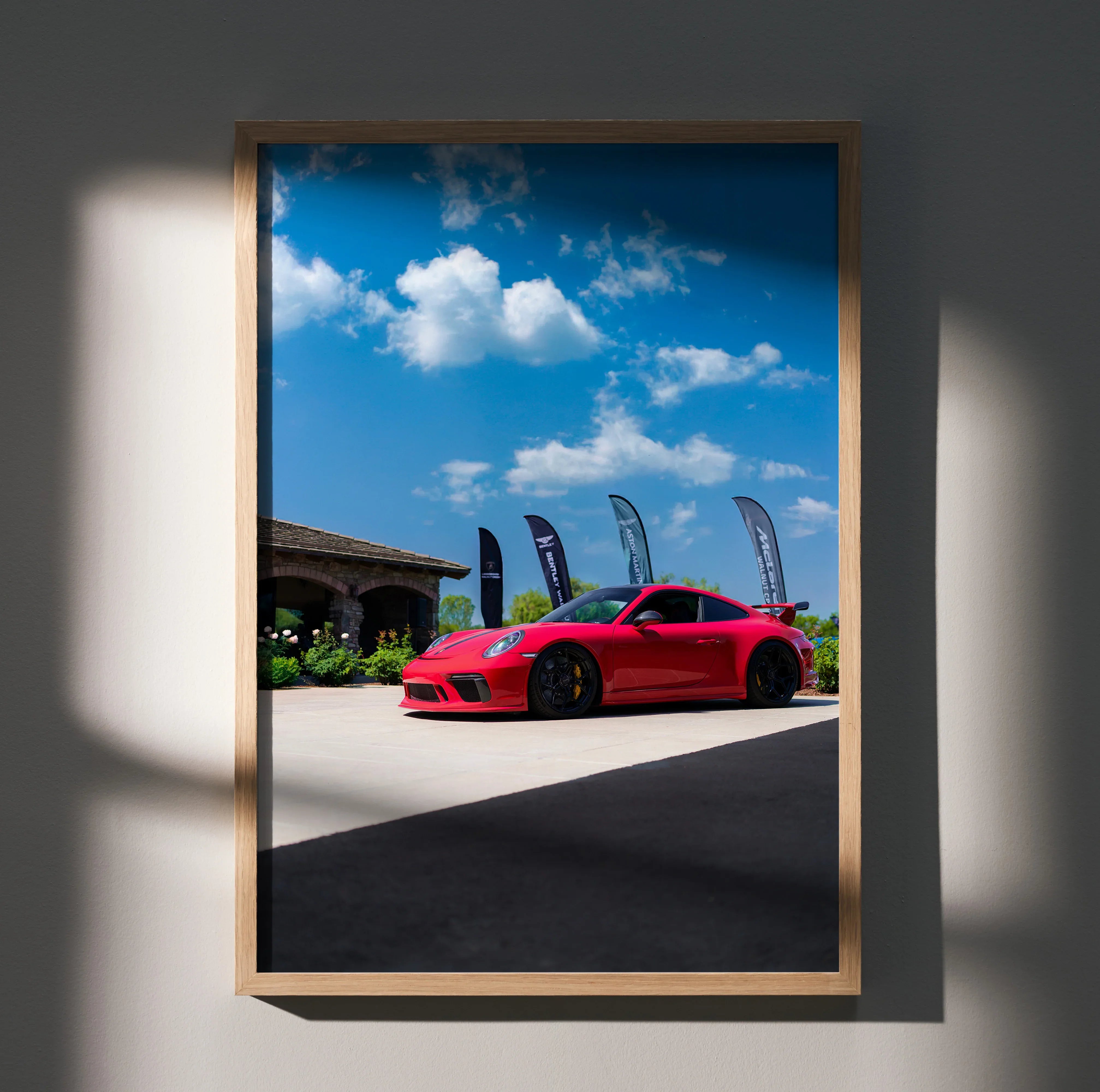 Red Porsche 911 GT3 parked under blue sky poster wall art in wooden frame.