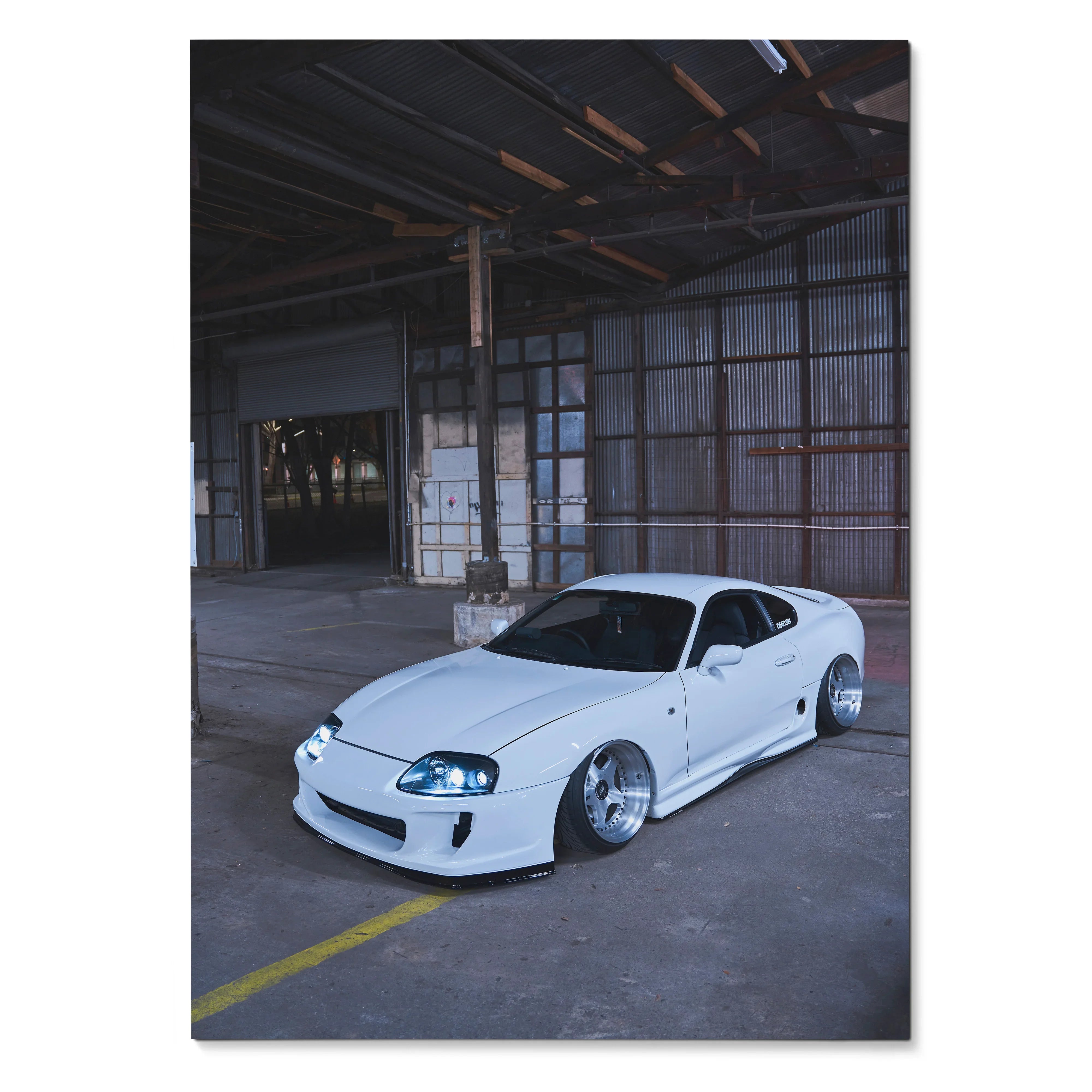 White Toyota Supra MK4 parked in industrial warehouse setting, automotive poster wall art.