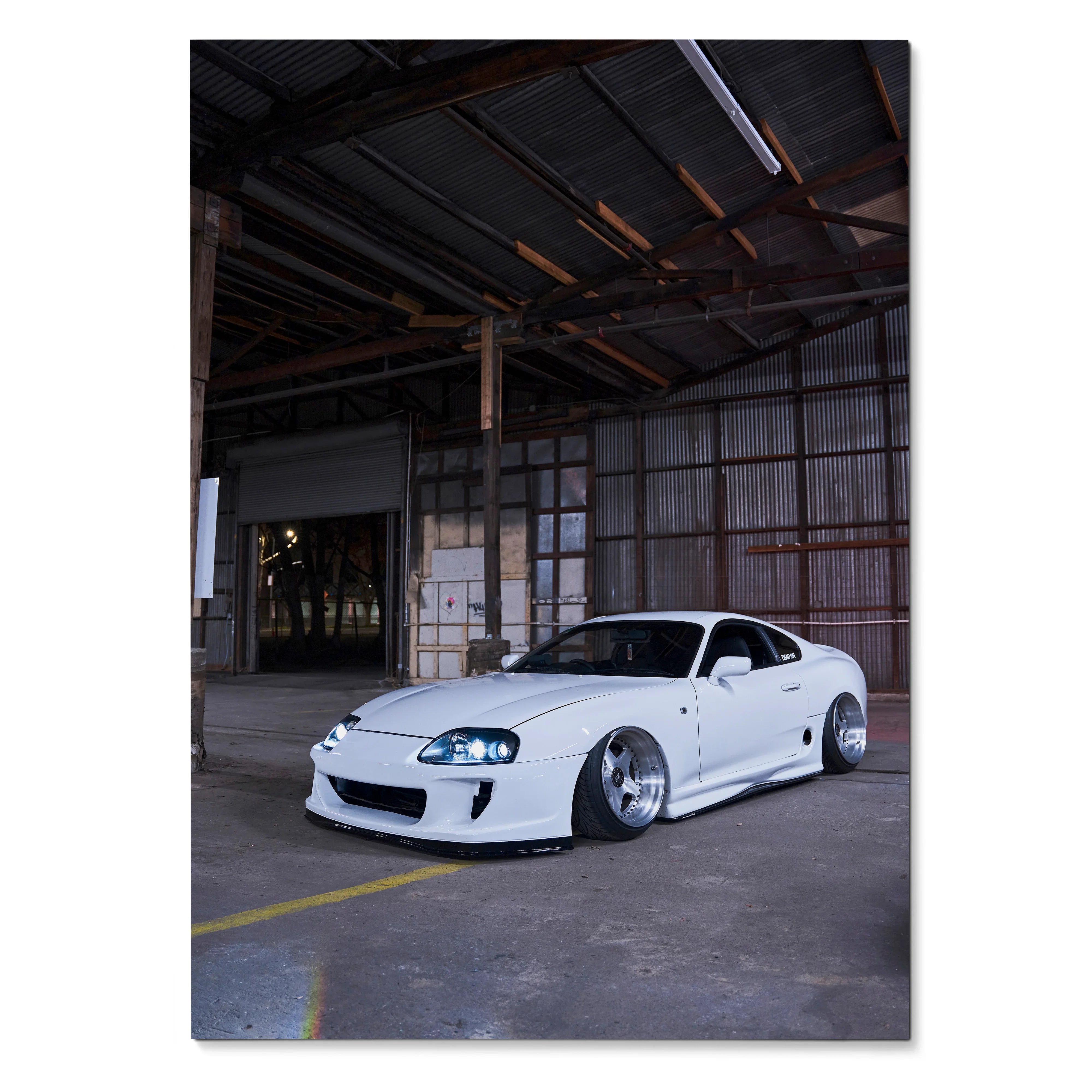 White Toyota Supra MK4 with lowered stance in industrial warehouse setting poster wall art.