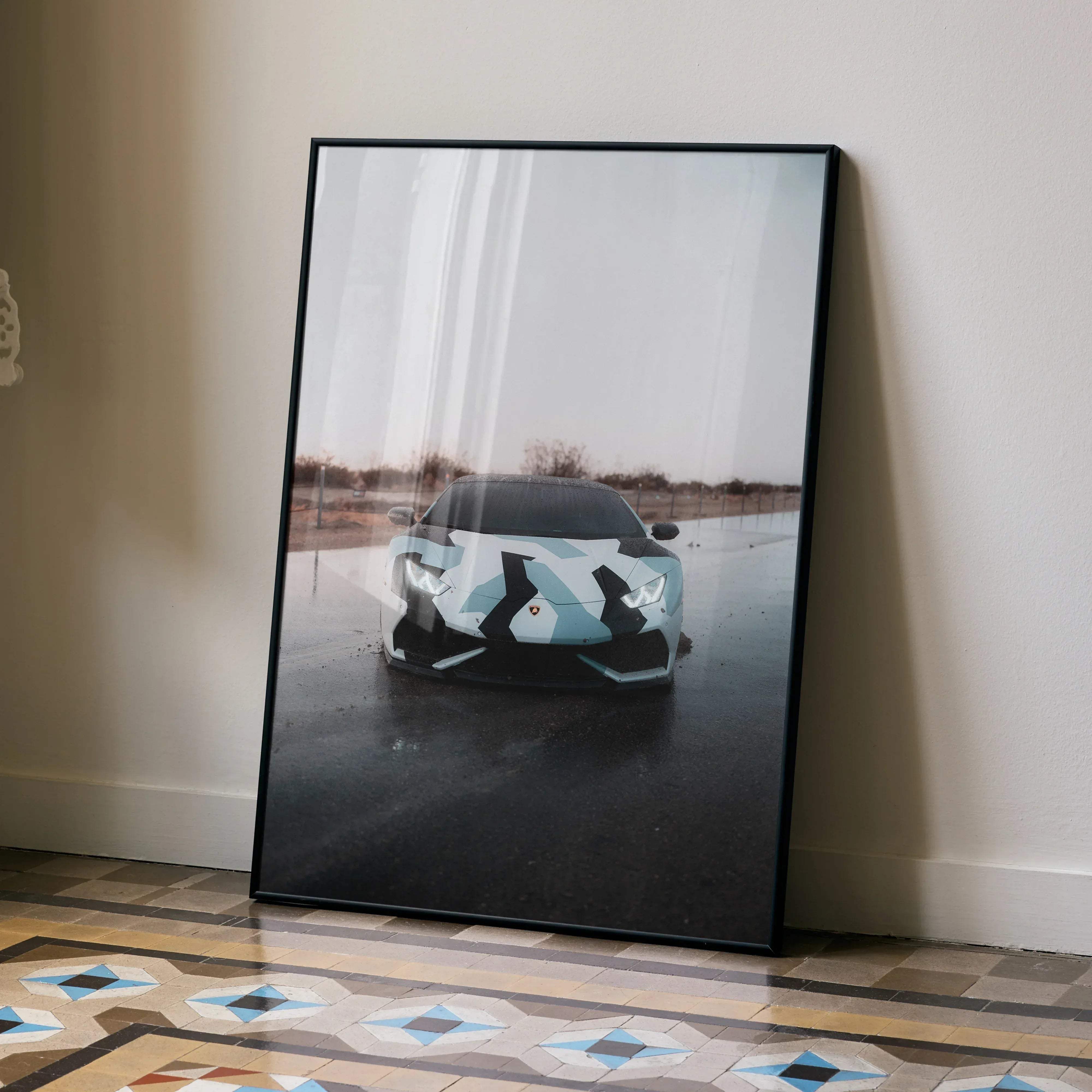 A framed poster featuring a light blue and black geometrically patterned Lamborghini Huracan sports car