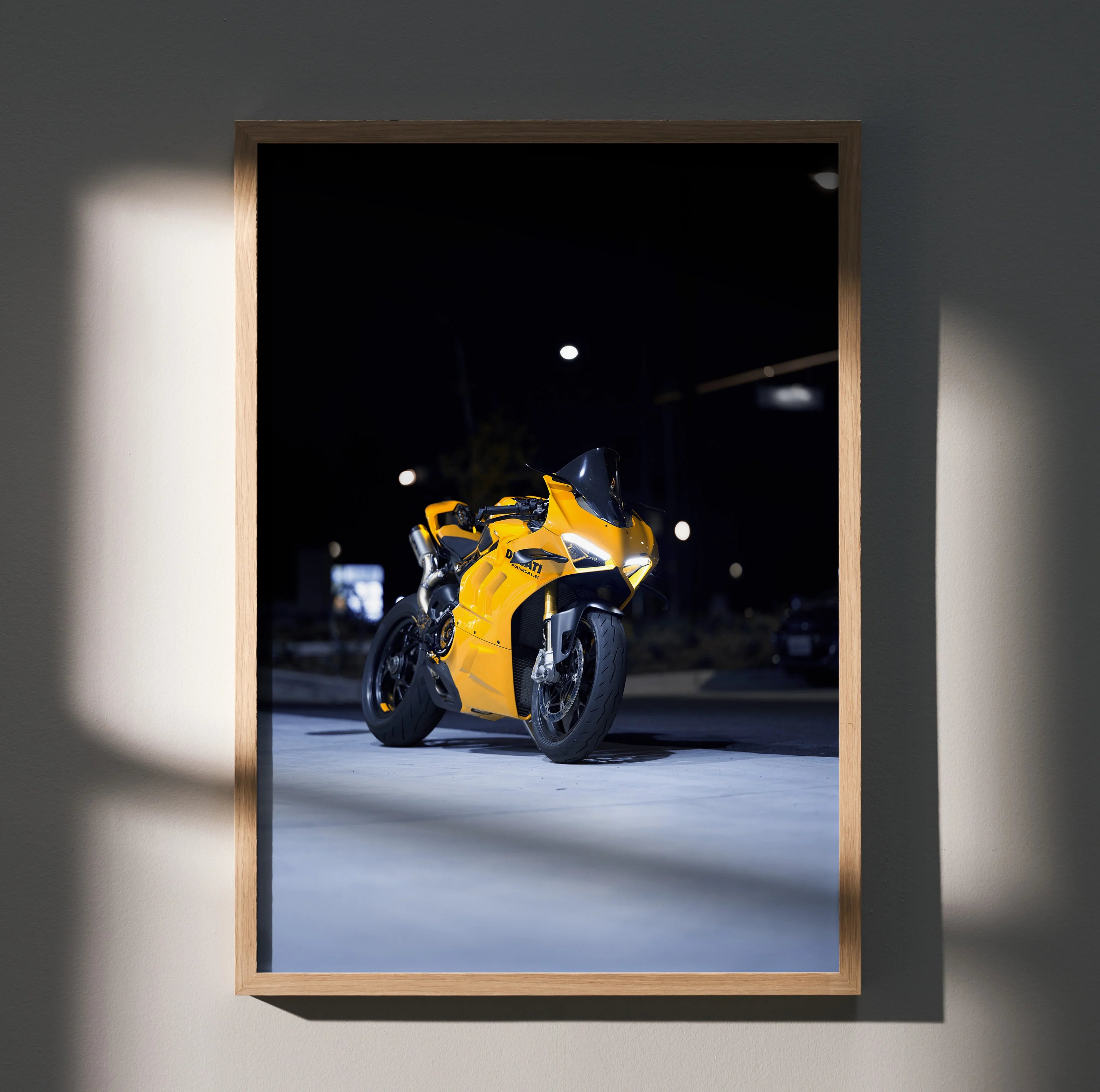 Ducati Panigale V4S bright yellow motorcycle poster framed as wall art in dim light.