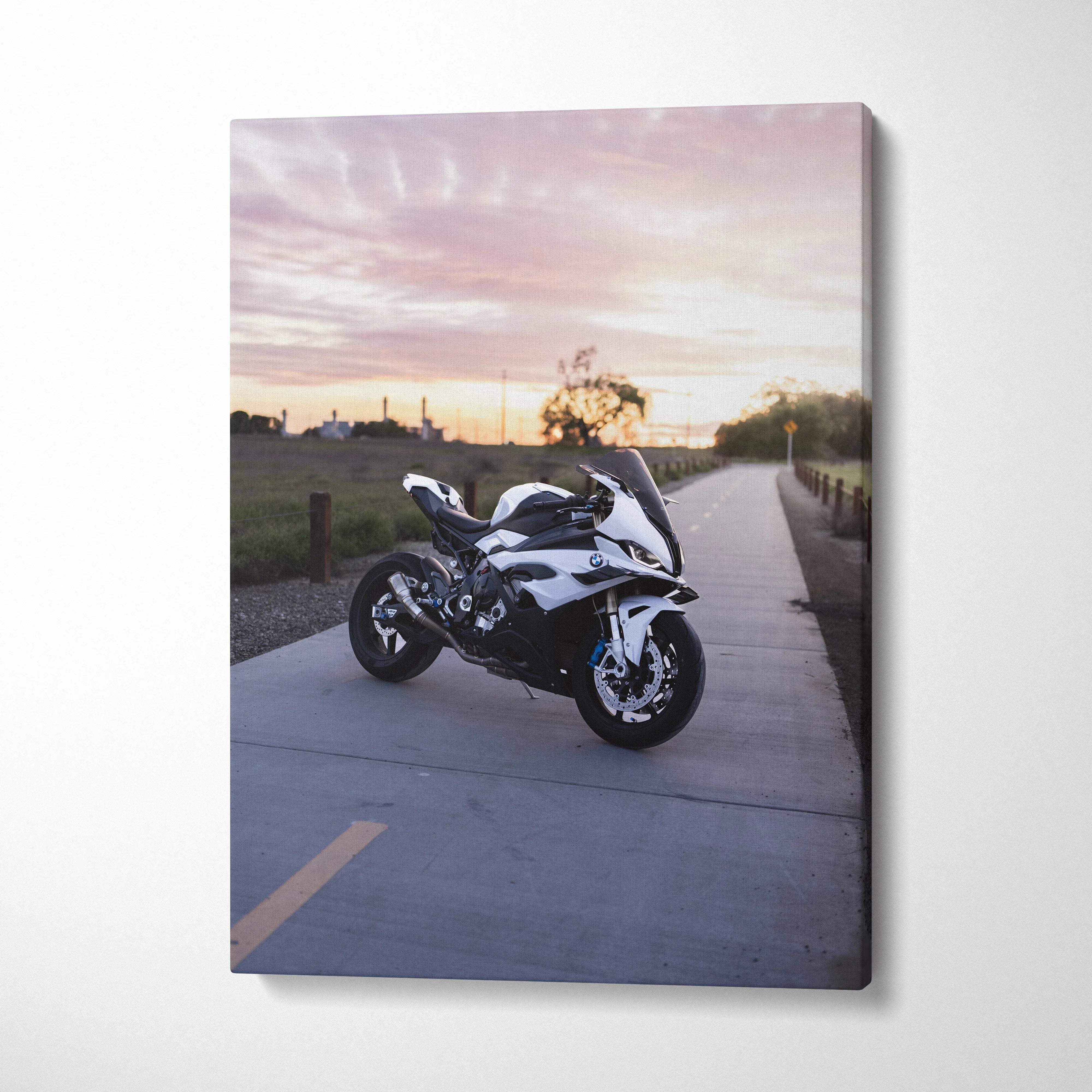 Vertical canvas wall art featuring a BMW S1000RR motorcycle at sunset on a roadside path.