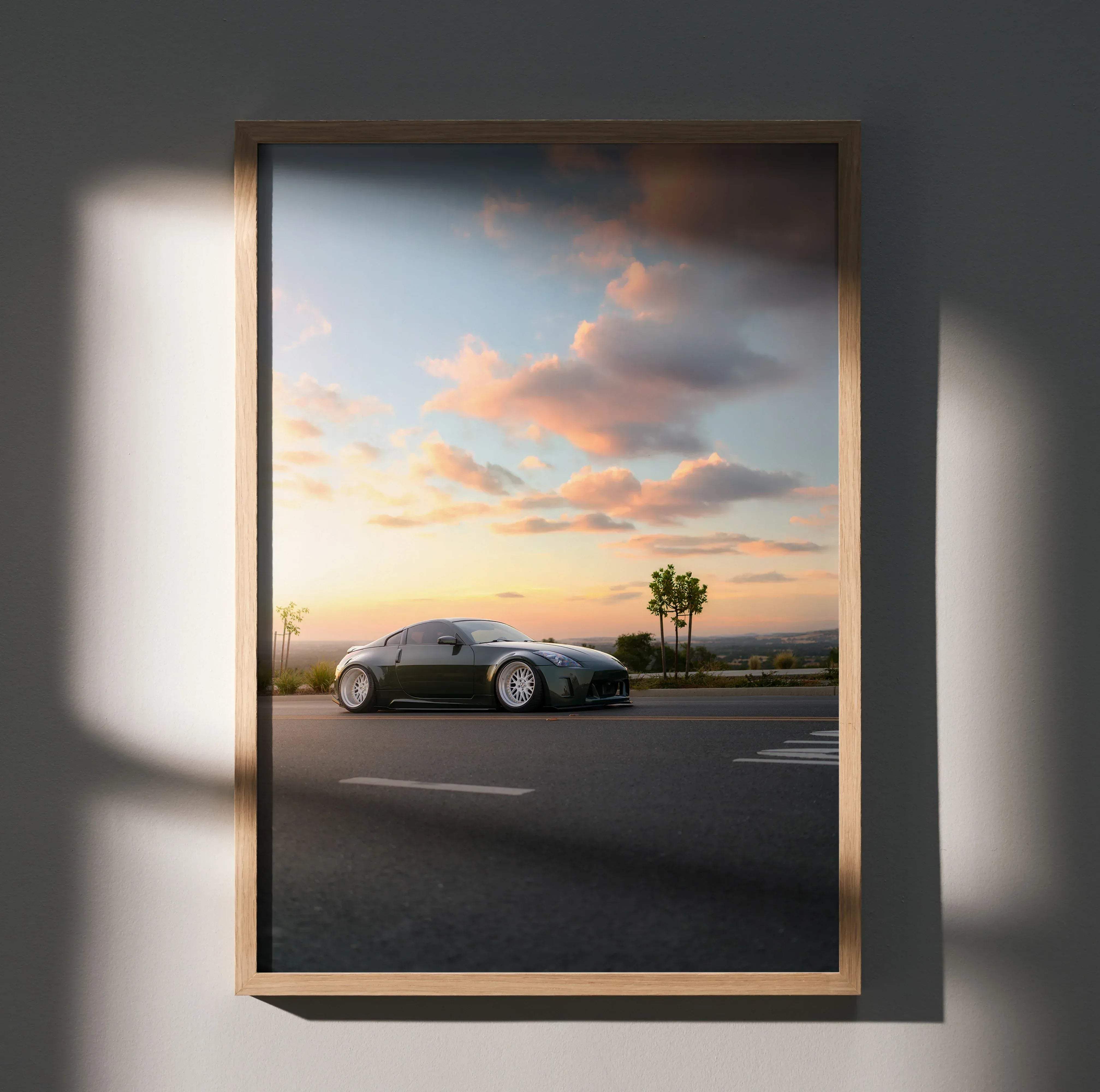 A framed photograph of a dark green Nissan 350z sports car parked on asphalt under a sunset sky poster