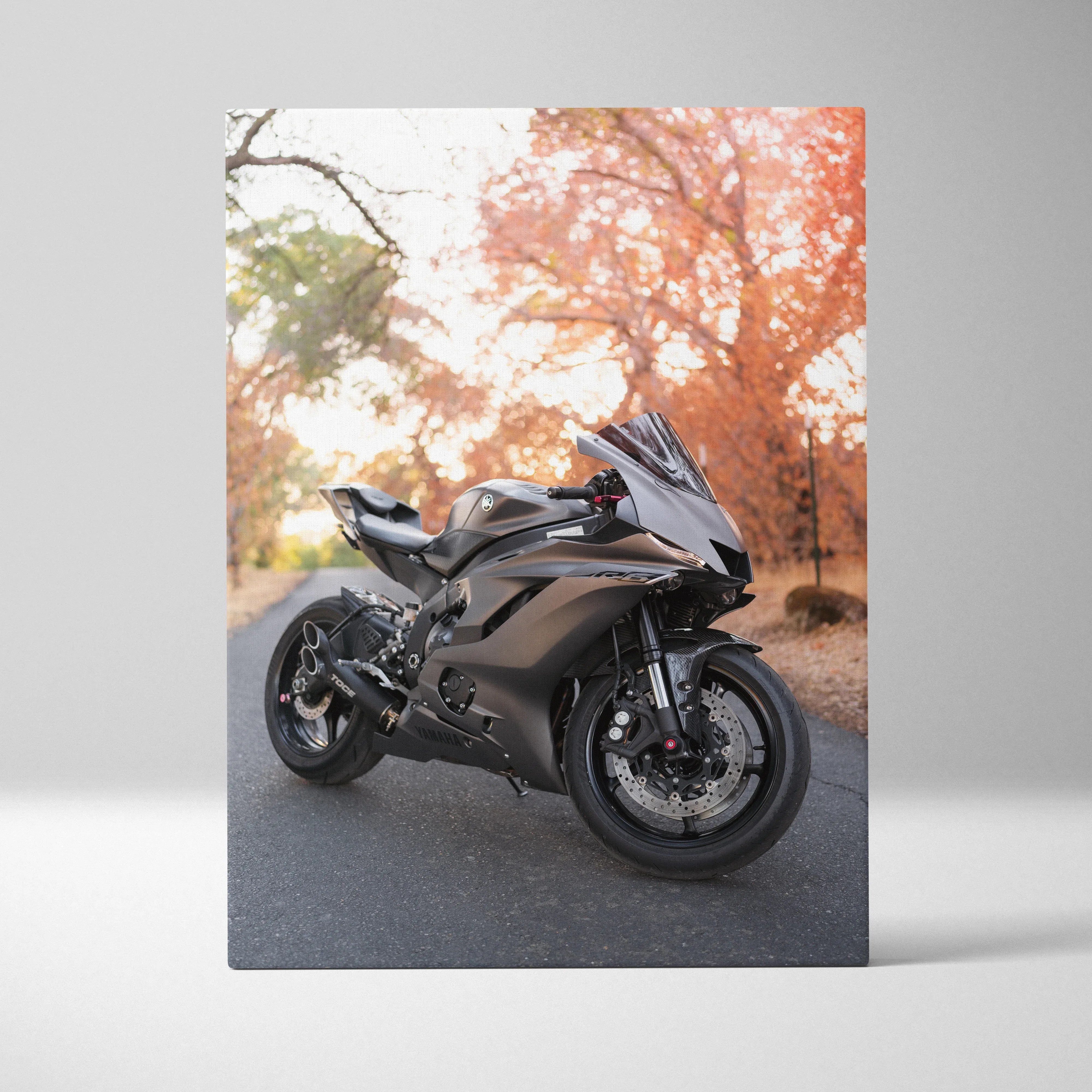 Yamaha R6 black sport motorcycle on road autumn trees canvas wall art vertical.