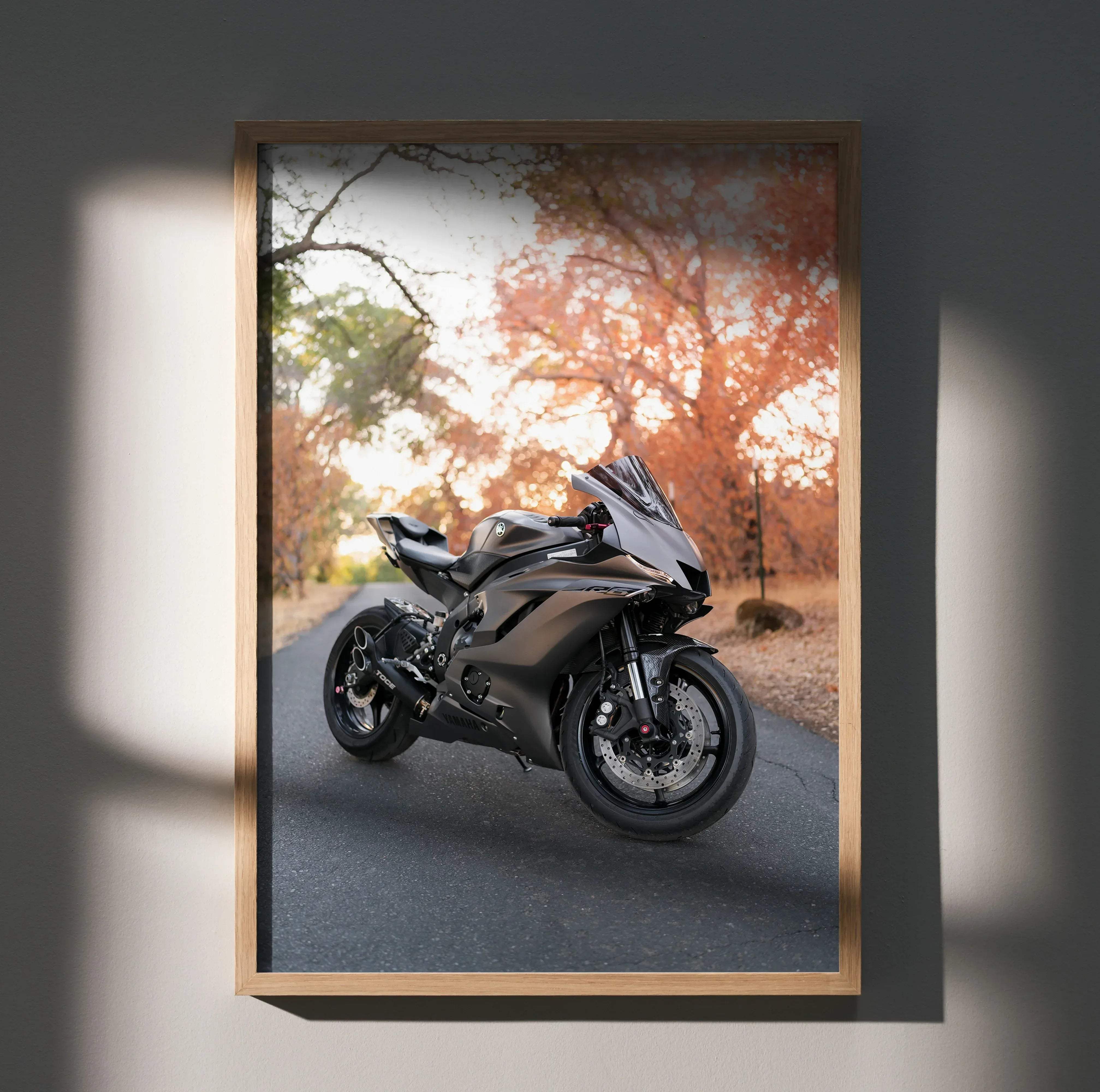 A sleek matte black yamaha r6 sport motorcycle photo print in a light wood frame for wall decor
