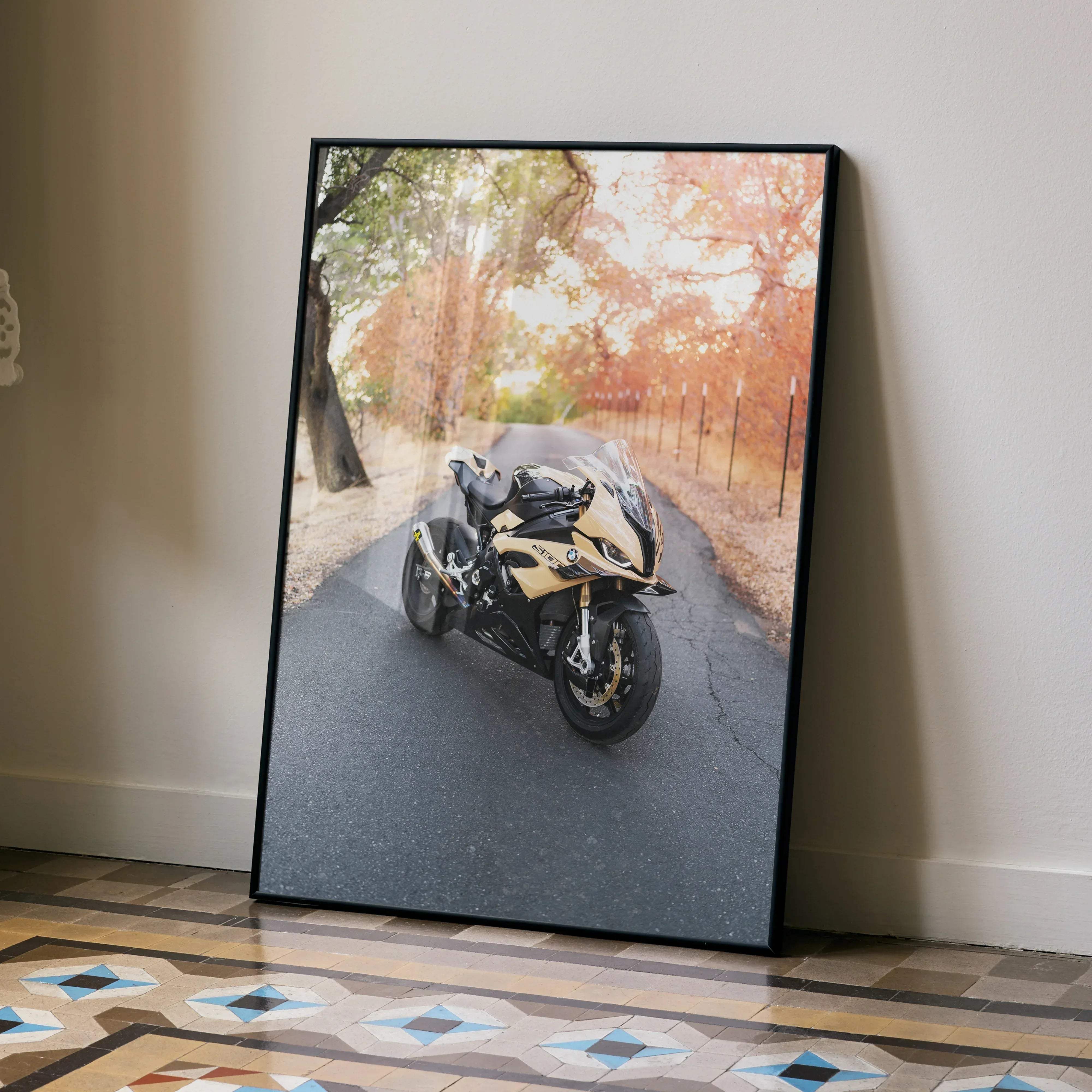 Black-framed canvas print of a gold and black BMW S1000RR motorcycle speeding down a tree-lined road poster