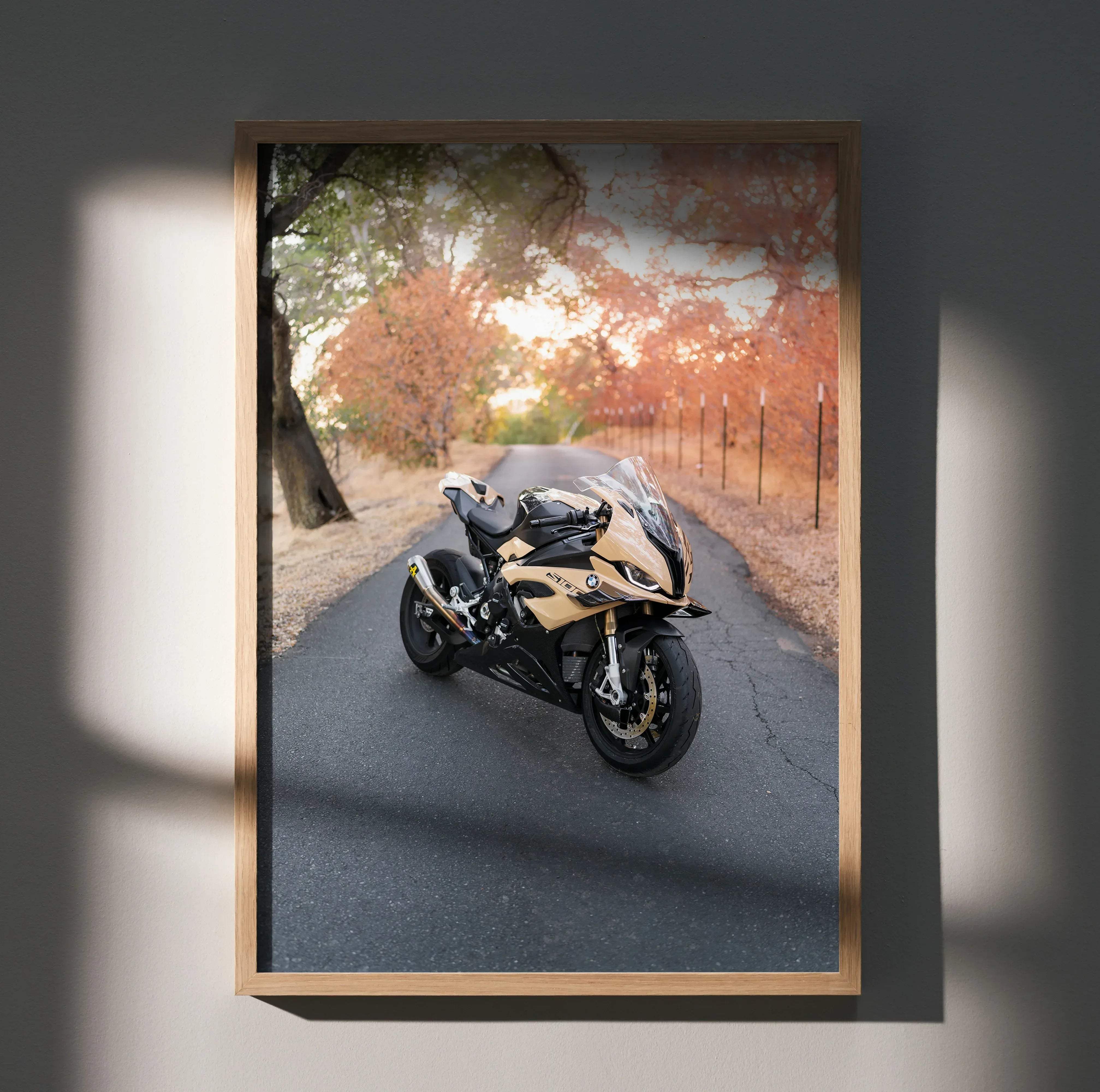 A framed high resolution poster of a gold and black bmw s1000rr motorcycle on an autumn road background