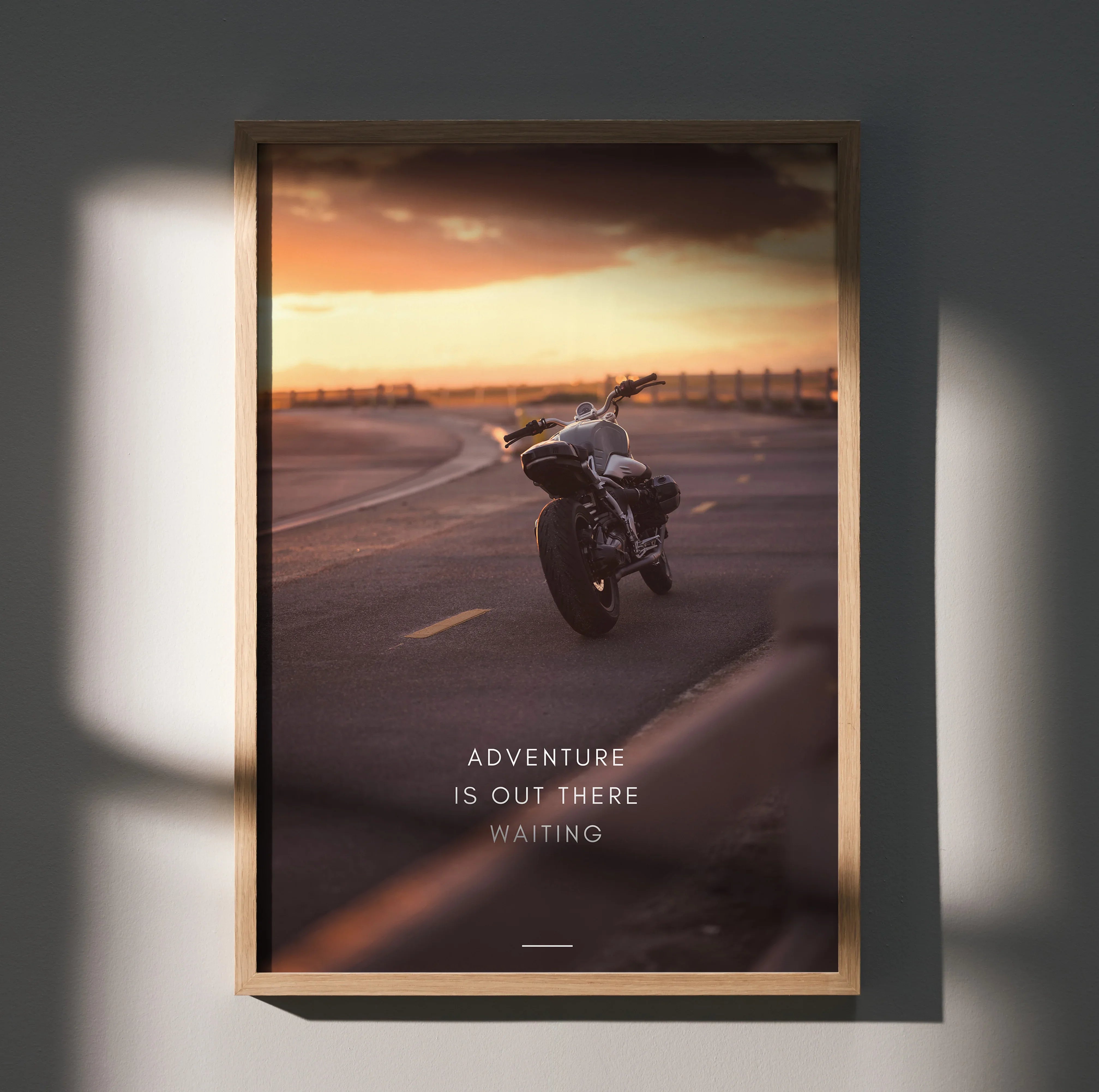 Motivational poster wall art featuring BMW R Nine T motorcycle on open road at sunset with inspiring text Adventure Is Out.
