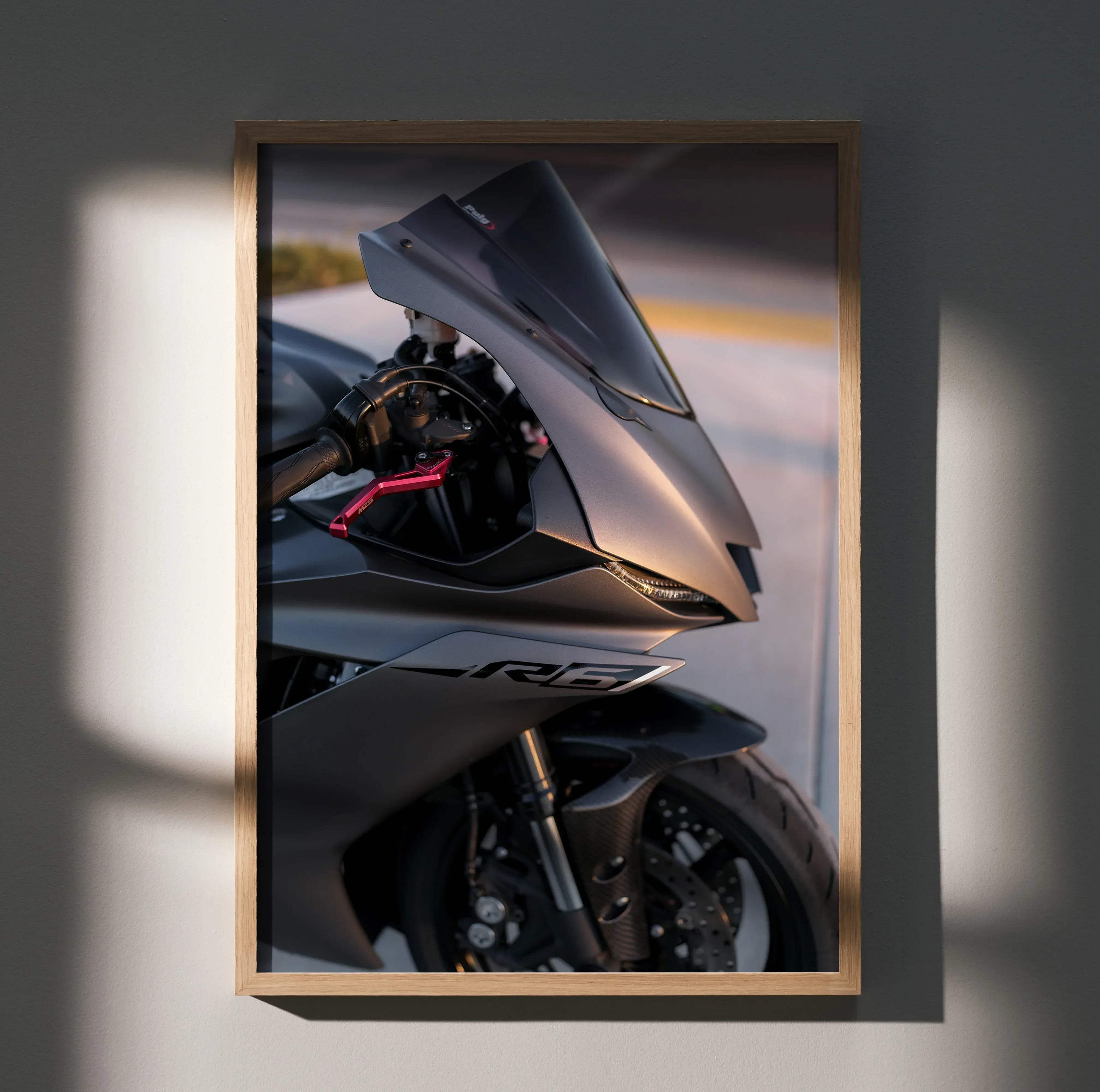 A framed photograph of a sleek matte black Yamaha R6 sport motorcycle poster with red accents and rb logo