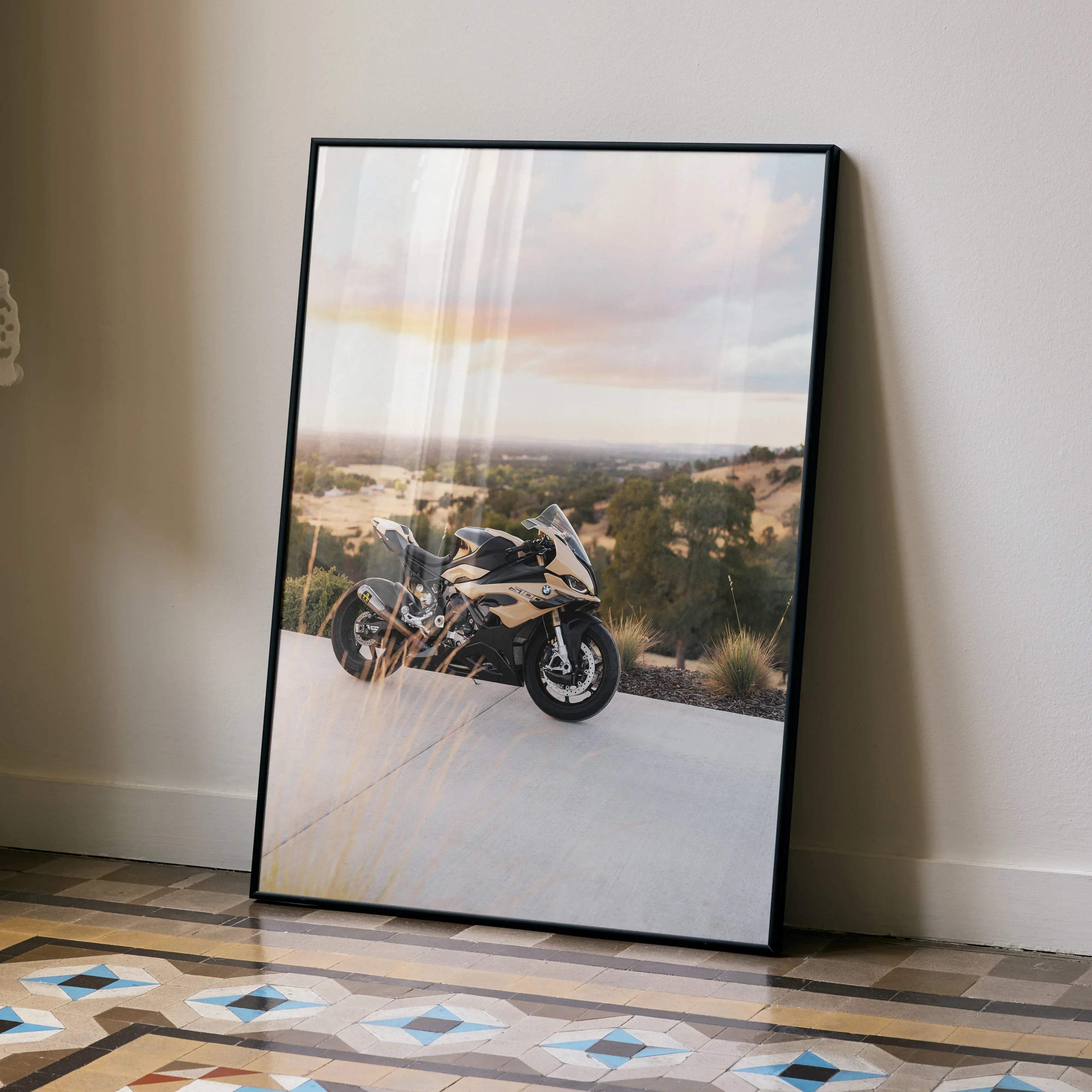 Black-framed poster of a beige and black bmw inspired s1000rr sport motorcycle on a paved road at sunset