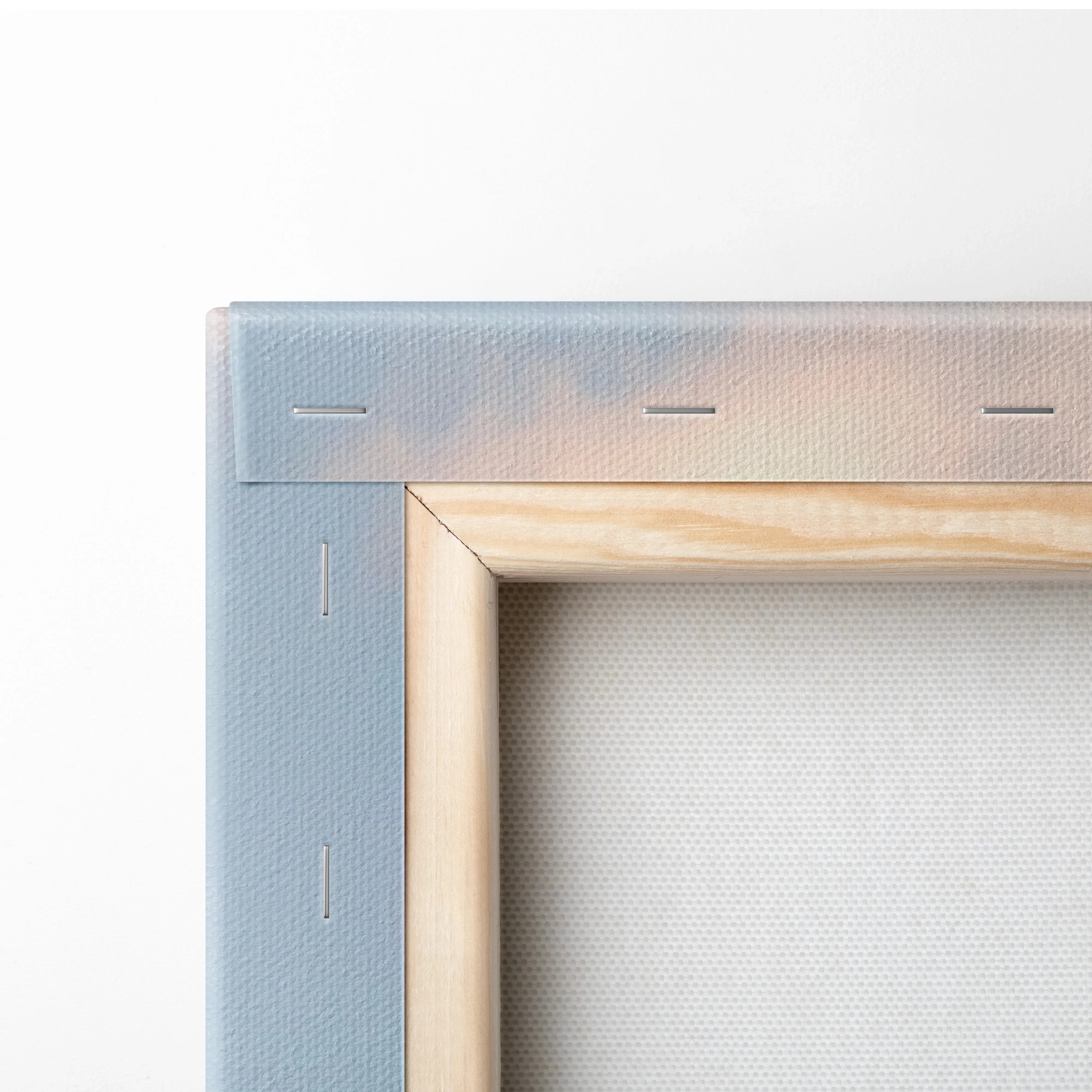 Close-up of wooden stretcher bars and stapled edges on blank canvas art for wall display.