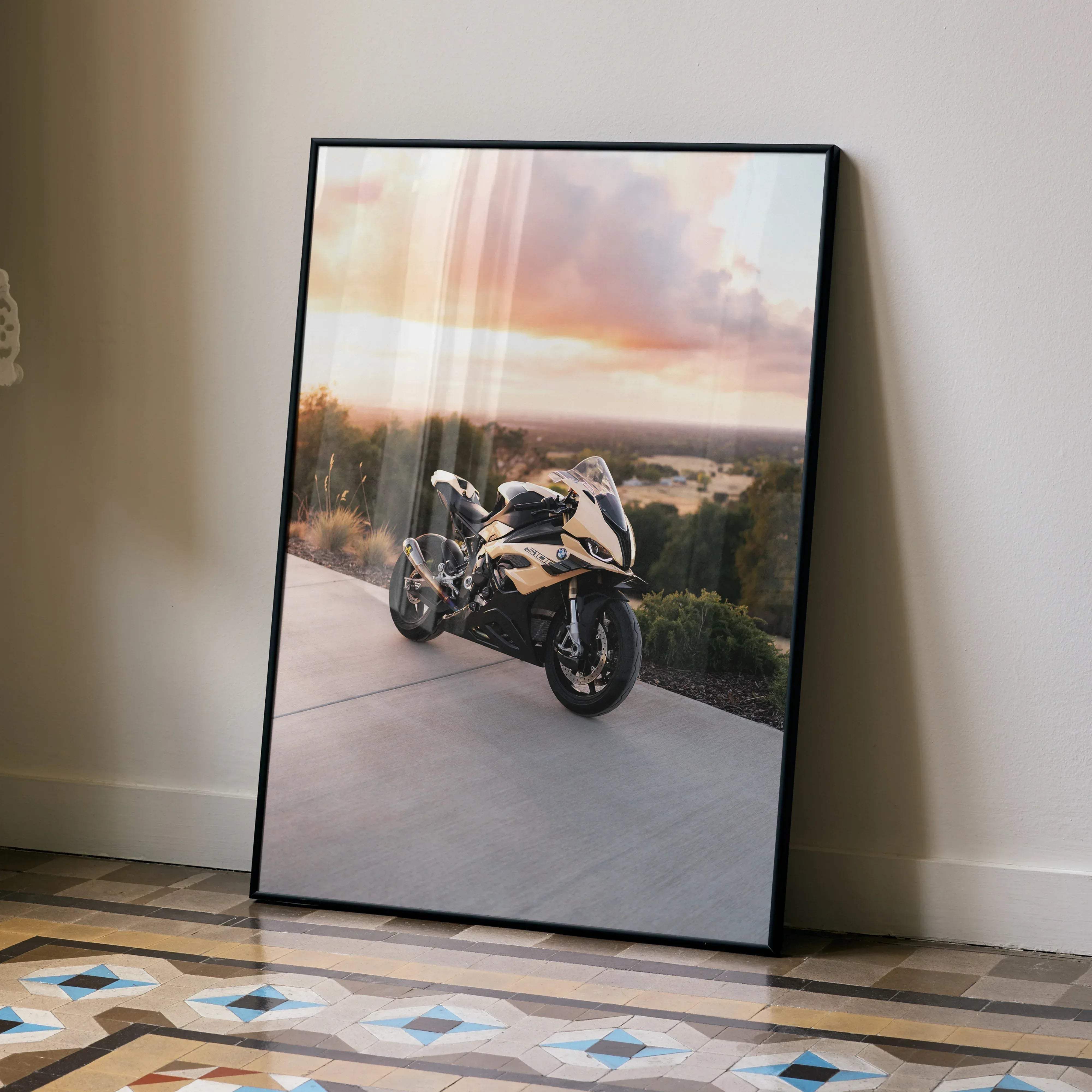 Black-framed poster of a gold and black bmw s1000rr motorcycle parked on a paved road at sunset