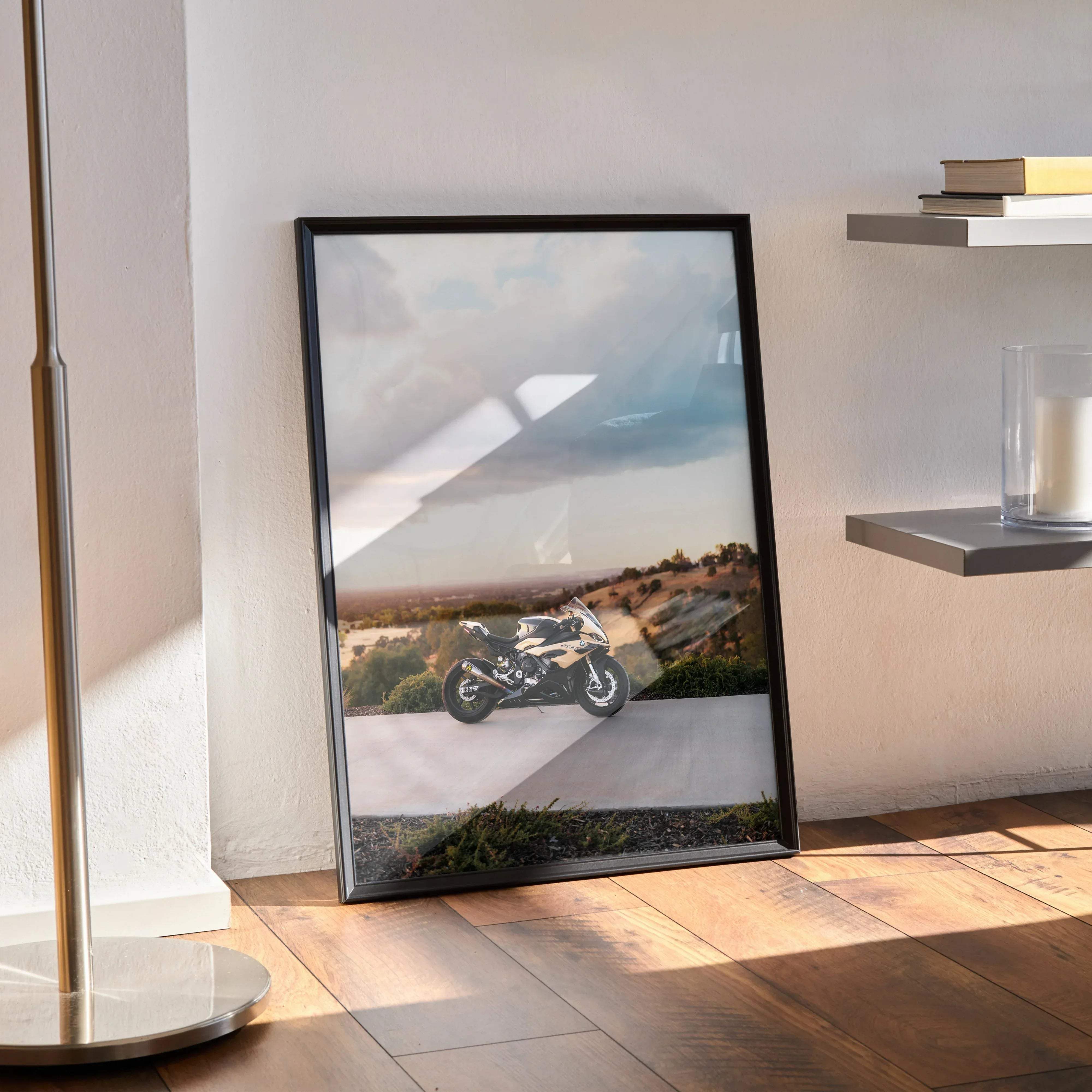 Black-framed poster of a white and black BMW inspired S1000RR motorcycle on a winding road under a cloudy sky