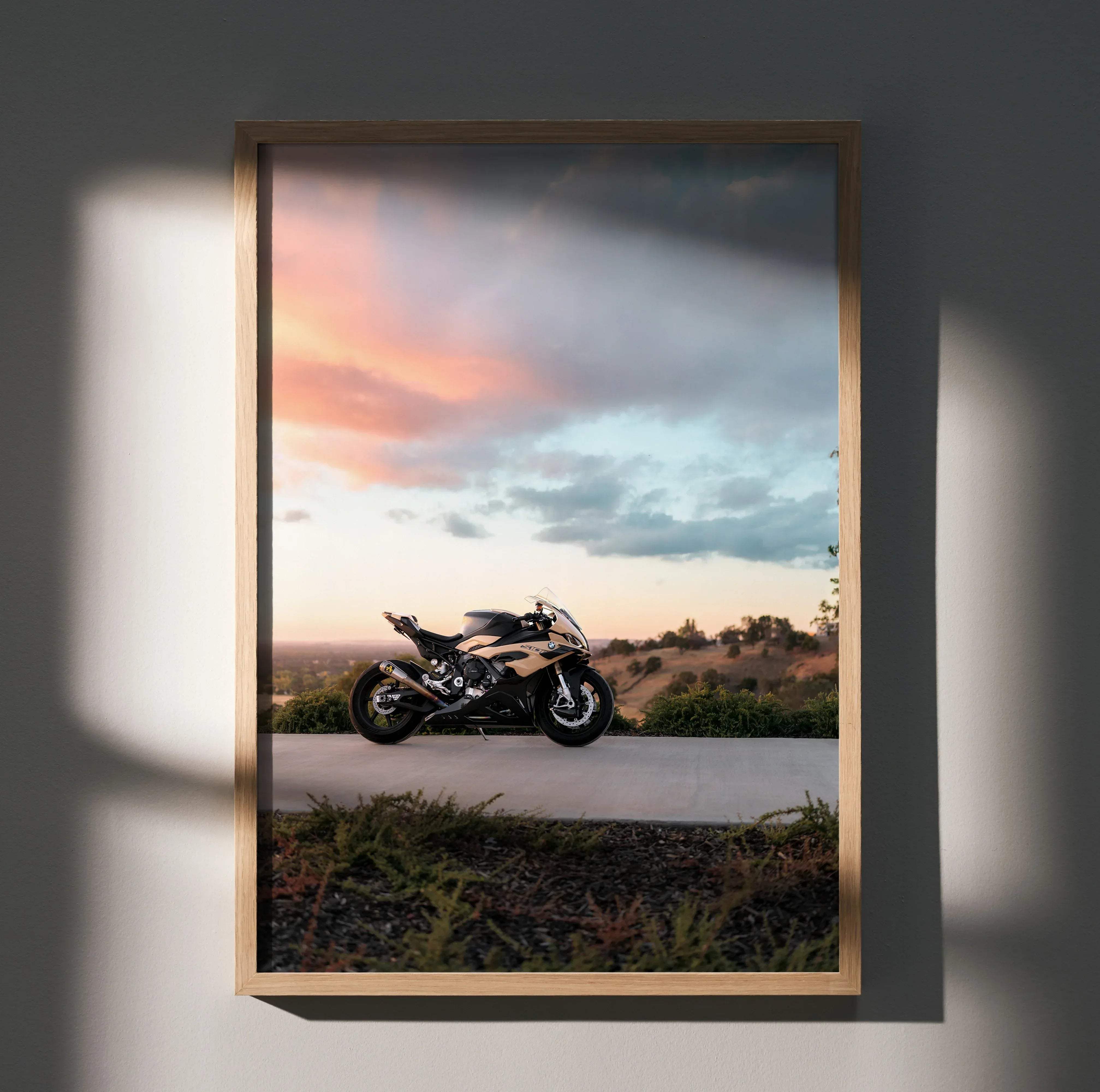 A framed high resolution poster of a black and gold BMW inspired S1000RR motorcycle at sunset on a road