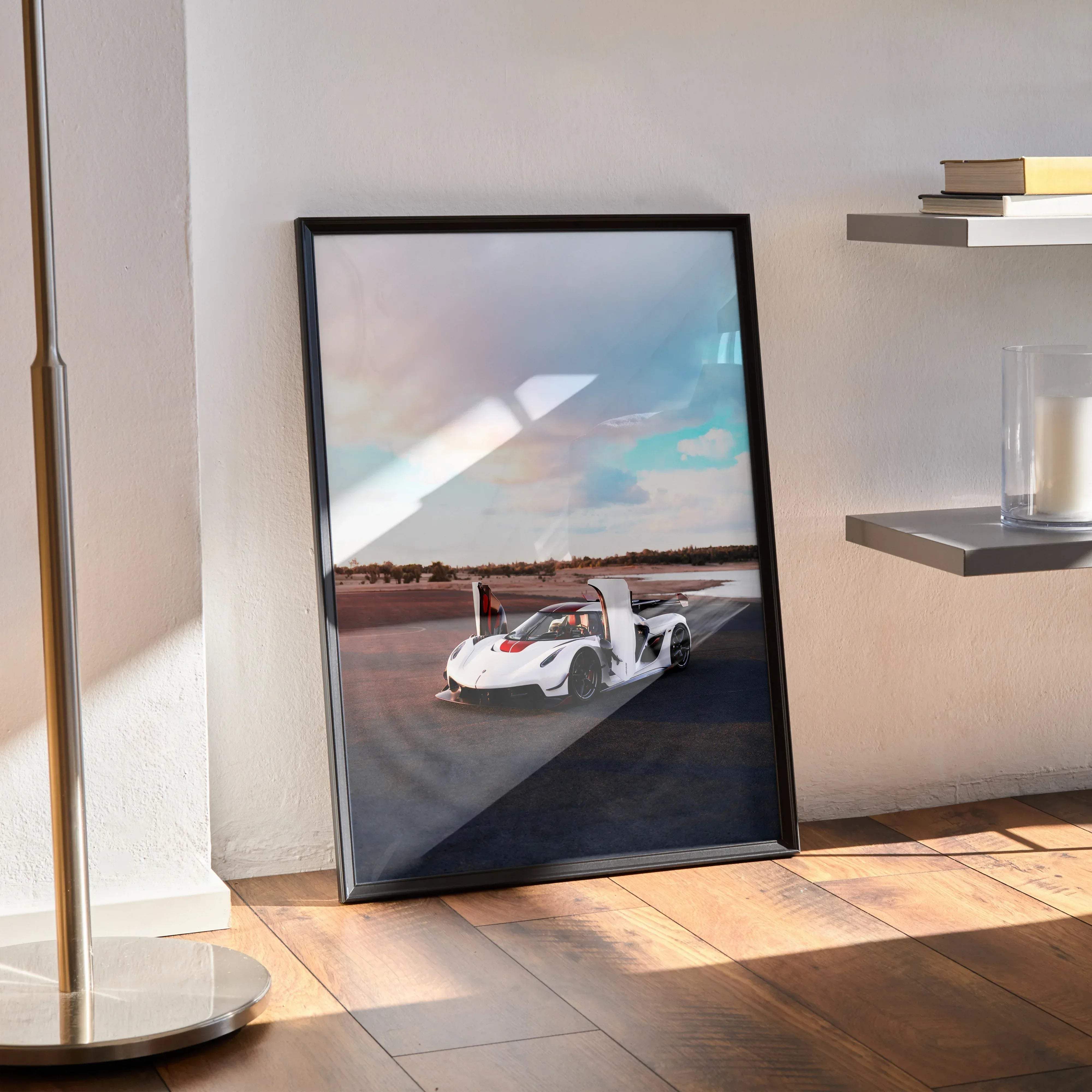Black-framed poster of a white and red koenigsegg jesko hypercar with open doors on an asphalt track under a cloudy sky