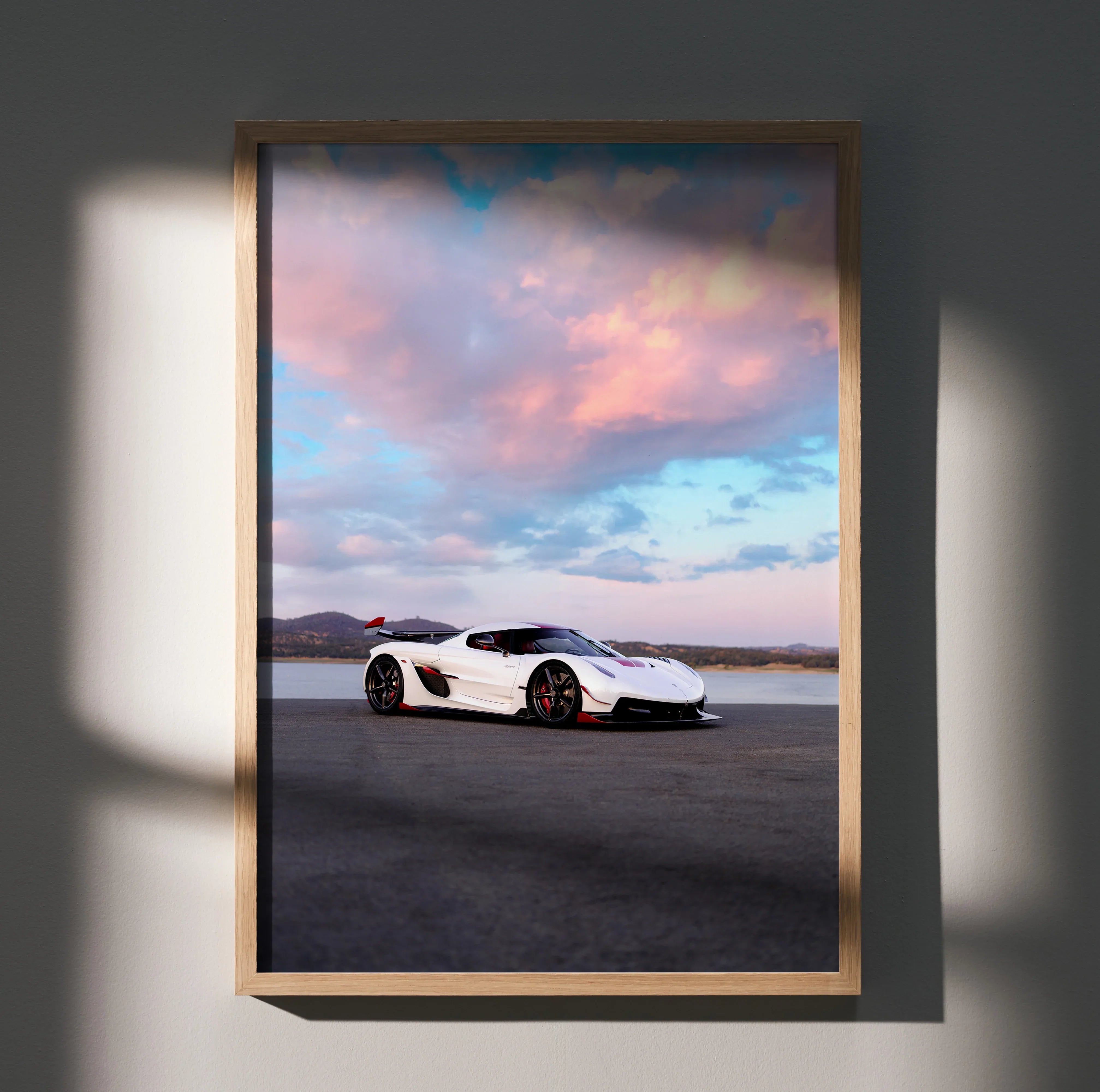 Koenigsegg Jesko poster featuring white sports car on open road under vibrant sunset sky wall art.