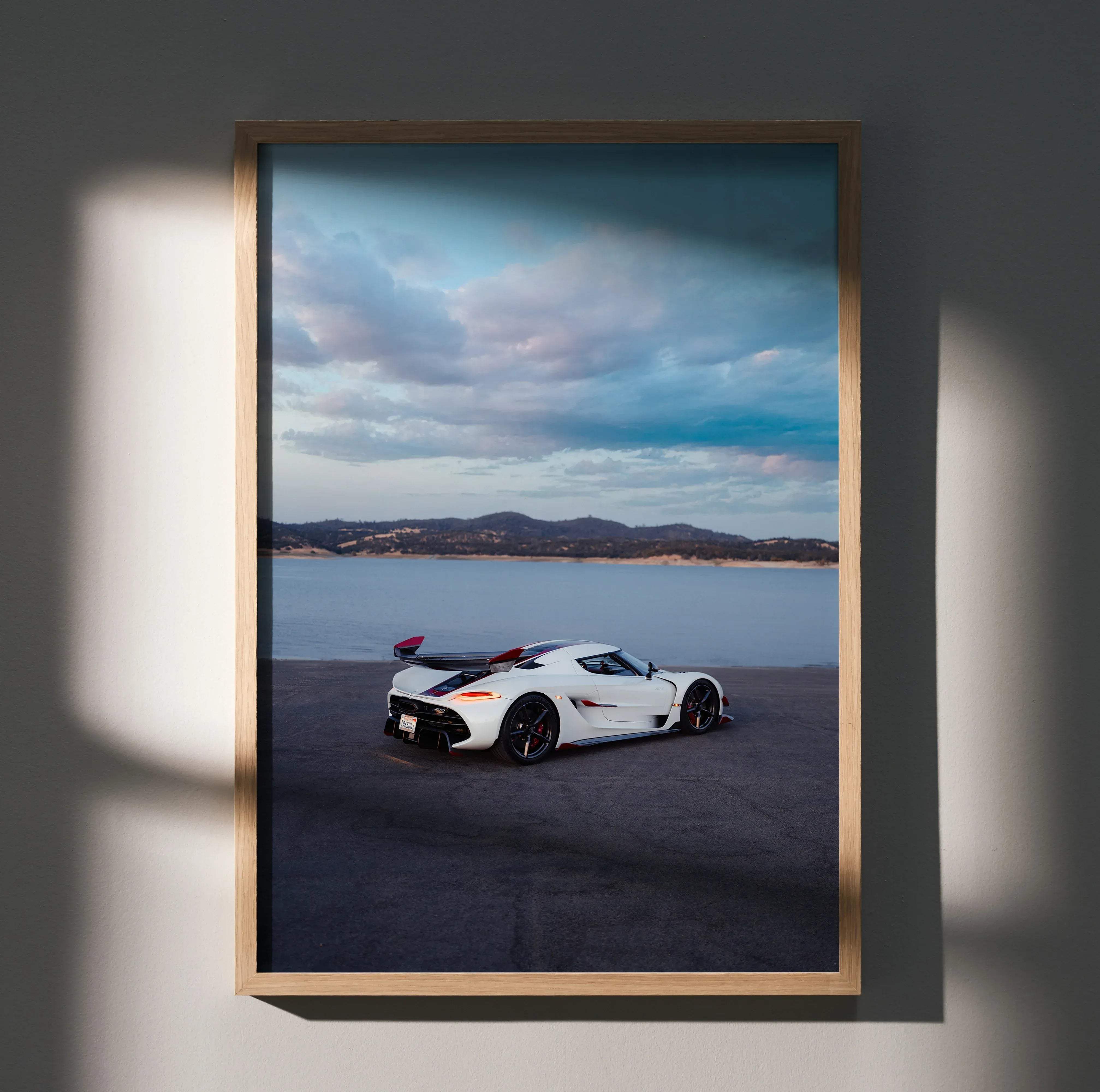 White Koenigsegg Jesko hypercar with red accents parked on a beach under a cloudy sky in high resolution poster
