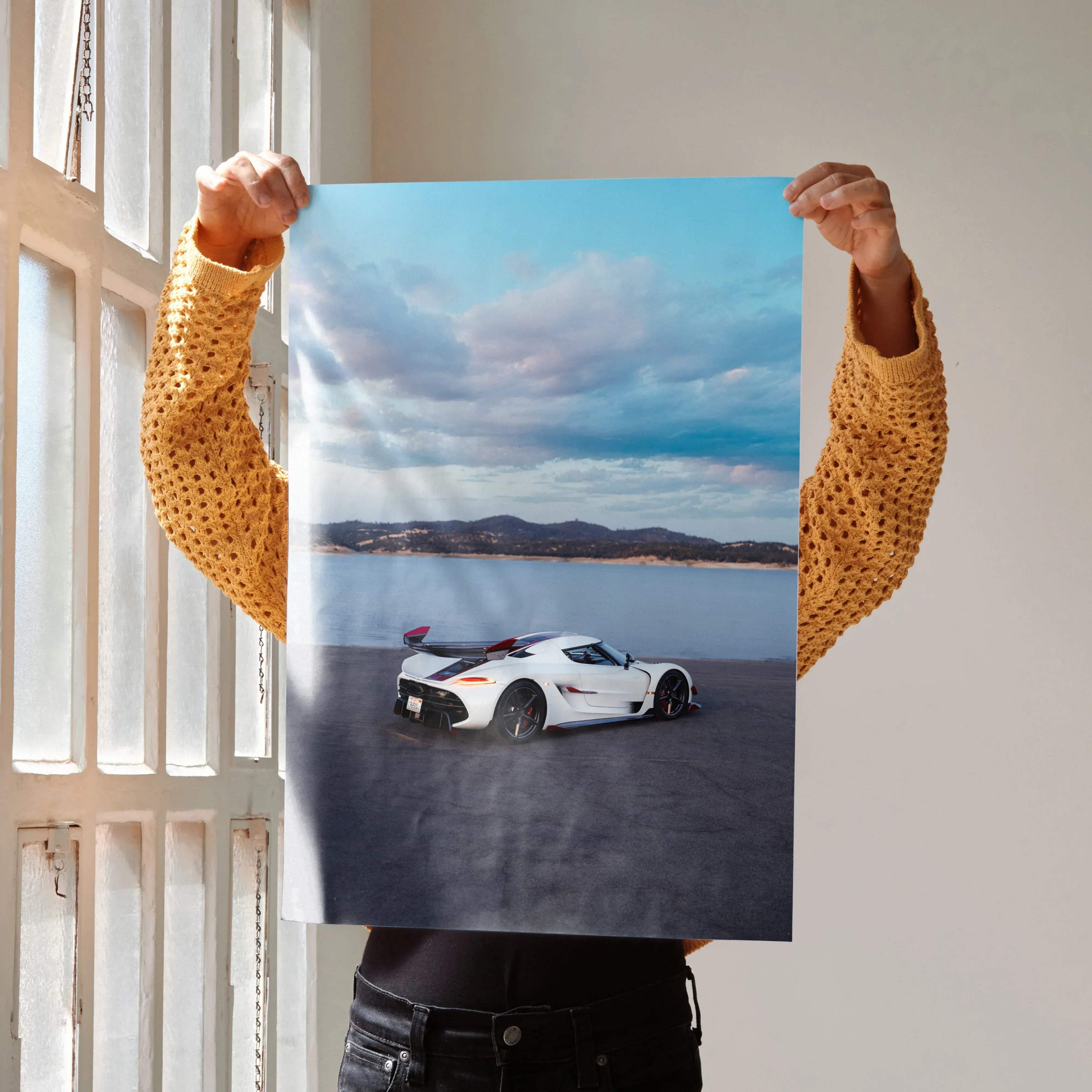 White koenigsegg jesko hypercar poster featuring sleek aerodynamic design with black and red accents under dramatic sky
