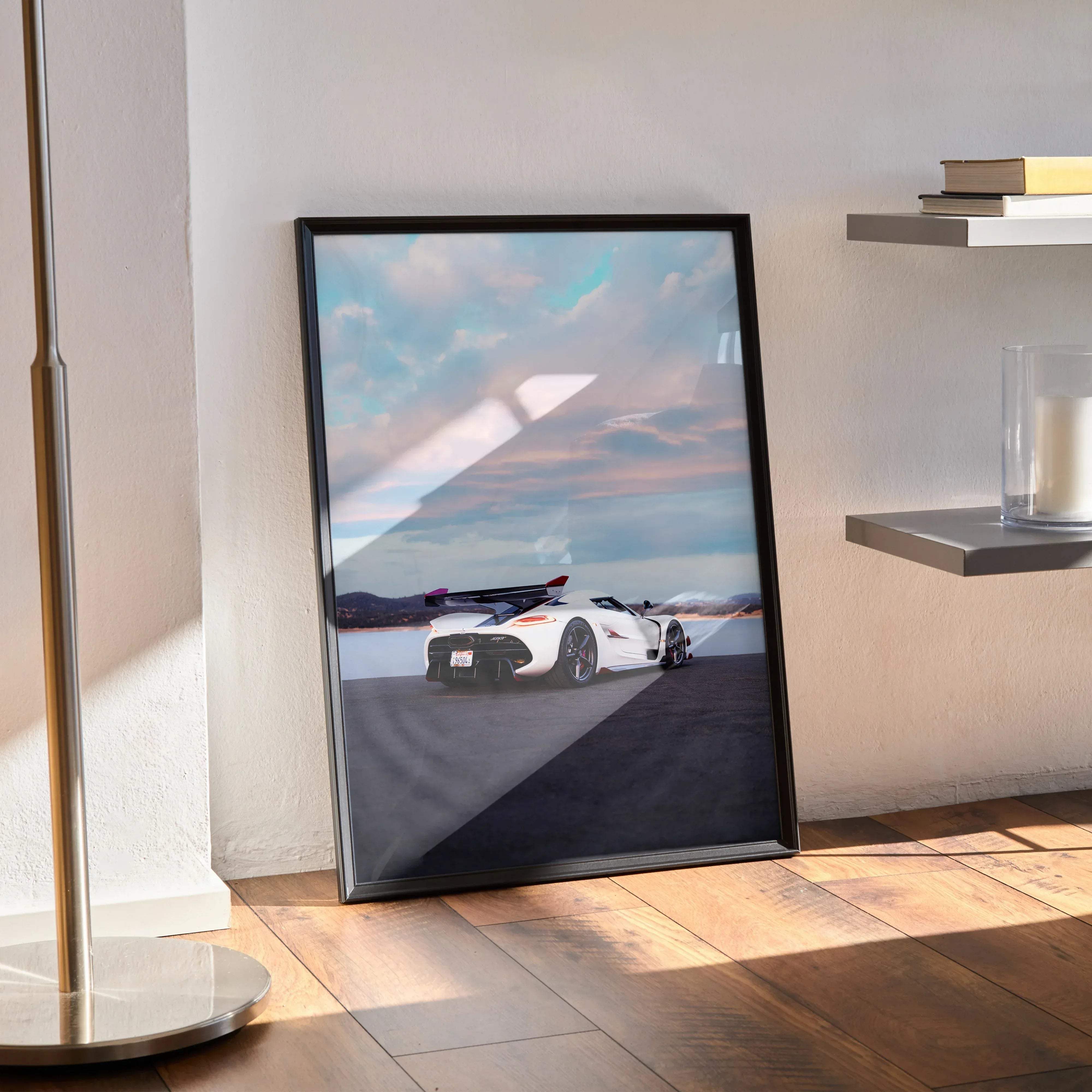 Black-framed poster of a white Koenigsegg Jesko hypercar speeding on asphalt under dramatic sky high resolution