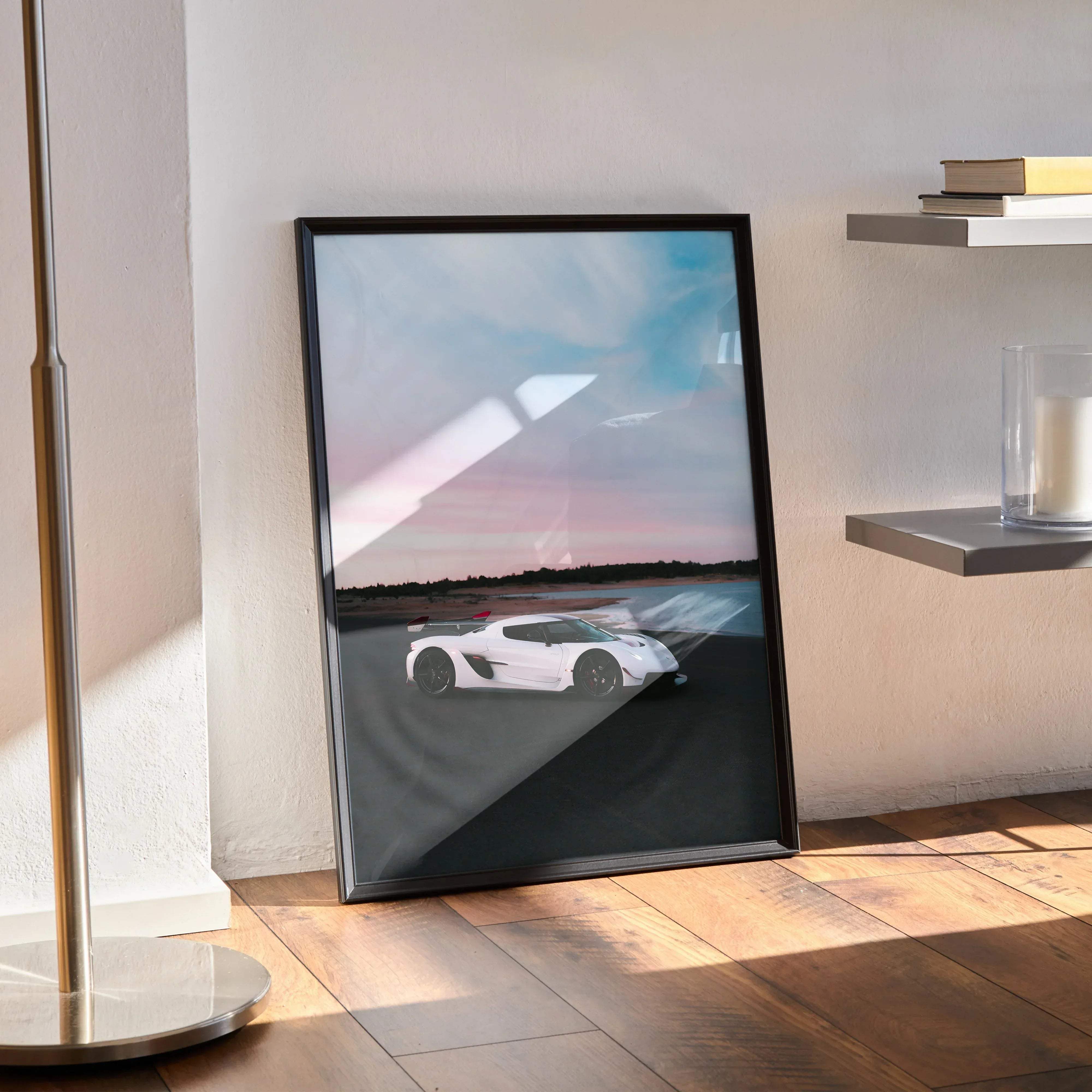 Black-framed poster of a white koenigsegg jesko hypercar speeding on a track under a twilight sky for wall decor