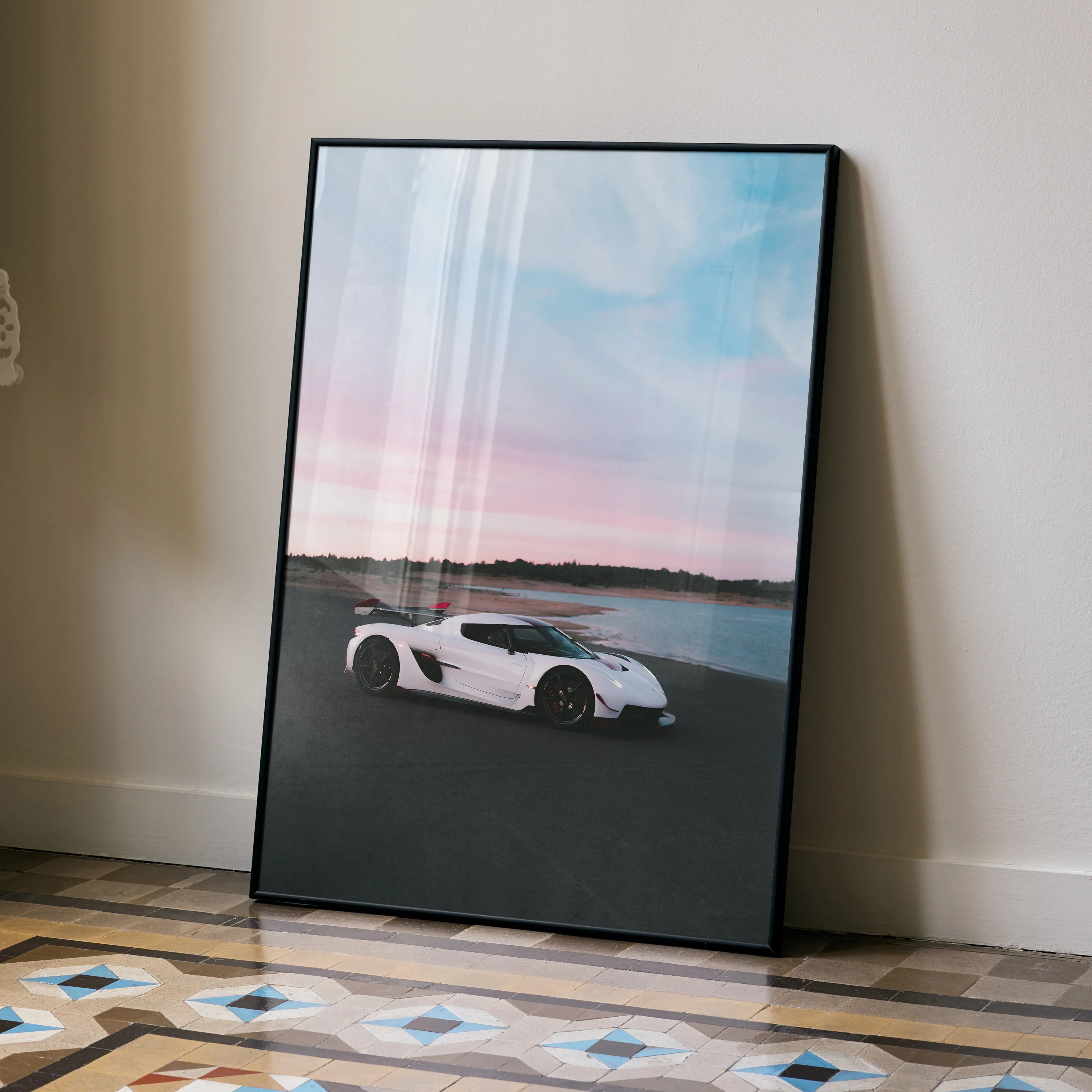 Koenigsegg Jesko poster wall art featuring white supercar on road by water at sunset.