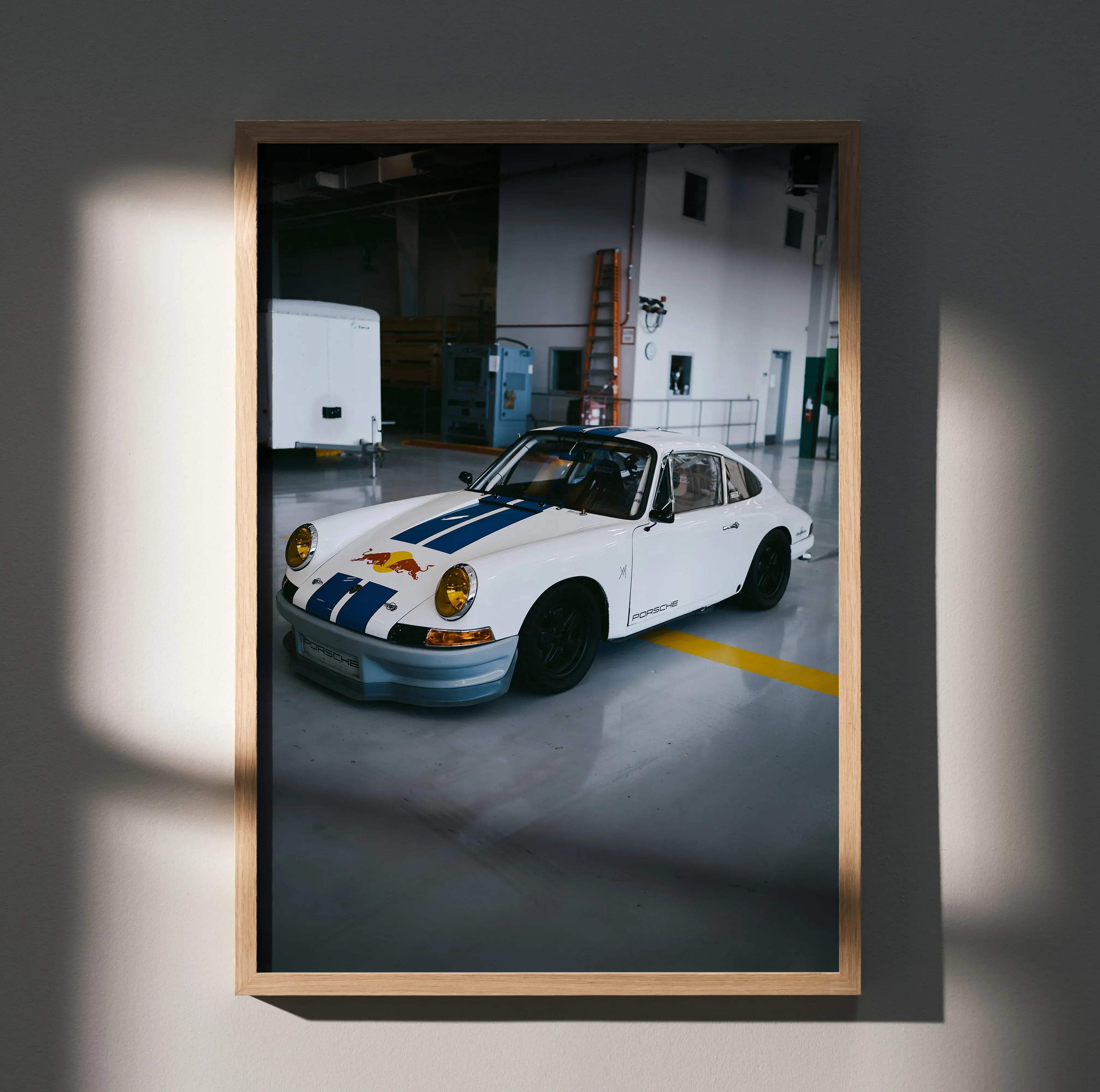 Framed photograph of a white porsche 911 with blue racing stripes and red bull logo in a classic high resolution poster