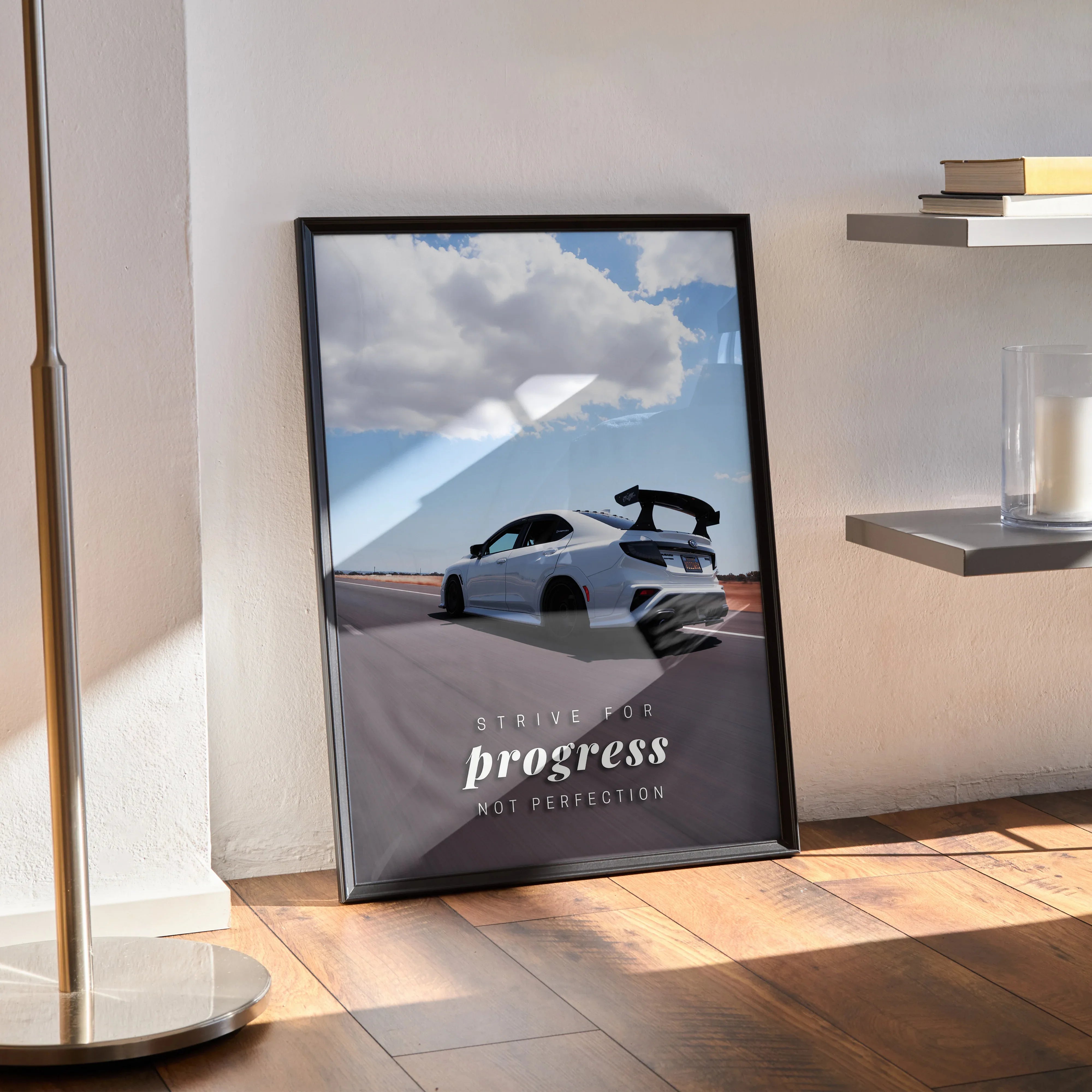 Subaru WRX STI poster with inspirational "Progress" text, framed wall art on wooden floor.