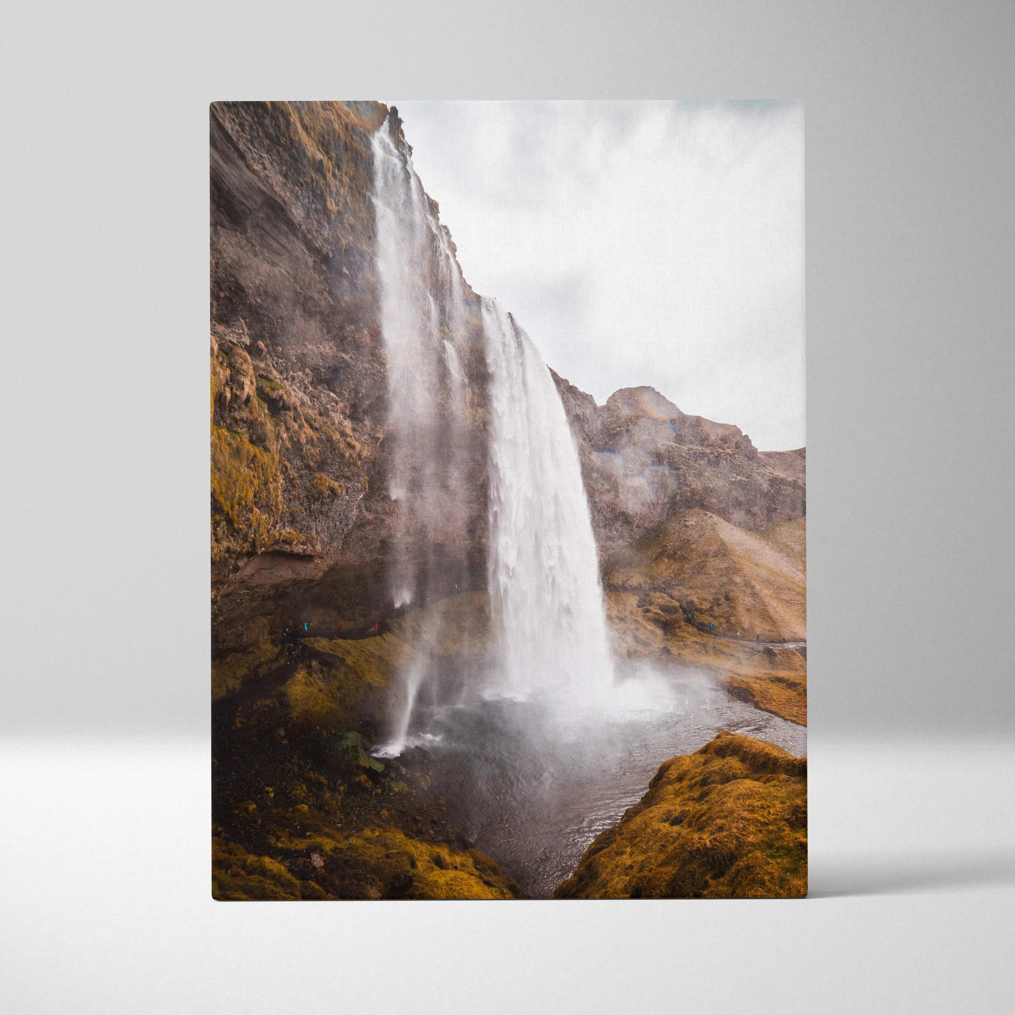 Rectangular canvas print of a dramatic iceland waterfall cascading down moss-covered cliffs into a misty pool for home decor