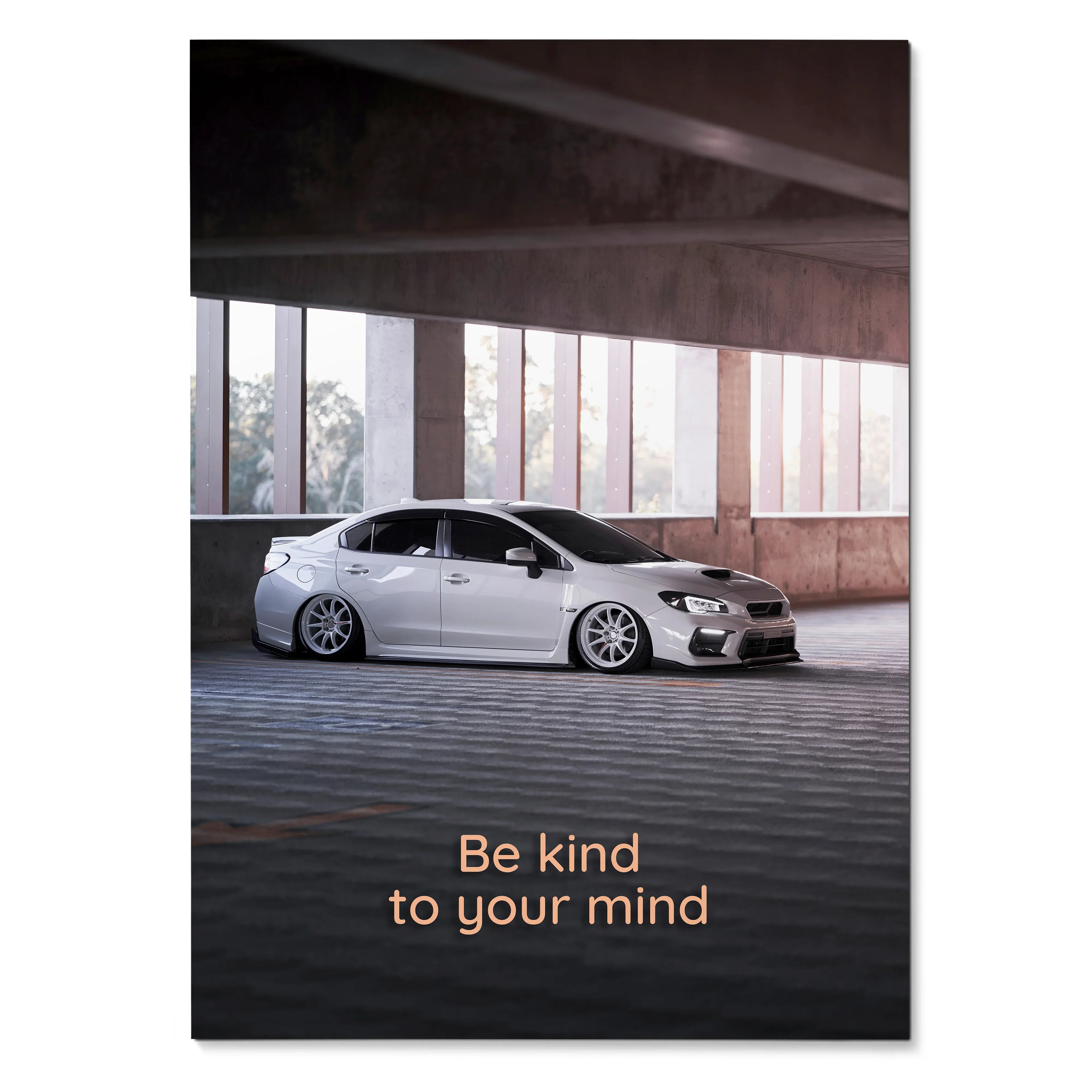 Subaru WRX parked under concrete structure with "Be kind to your mind" motivational text poster wall art.