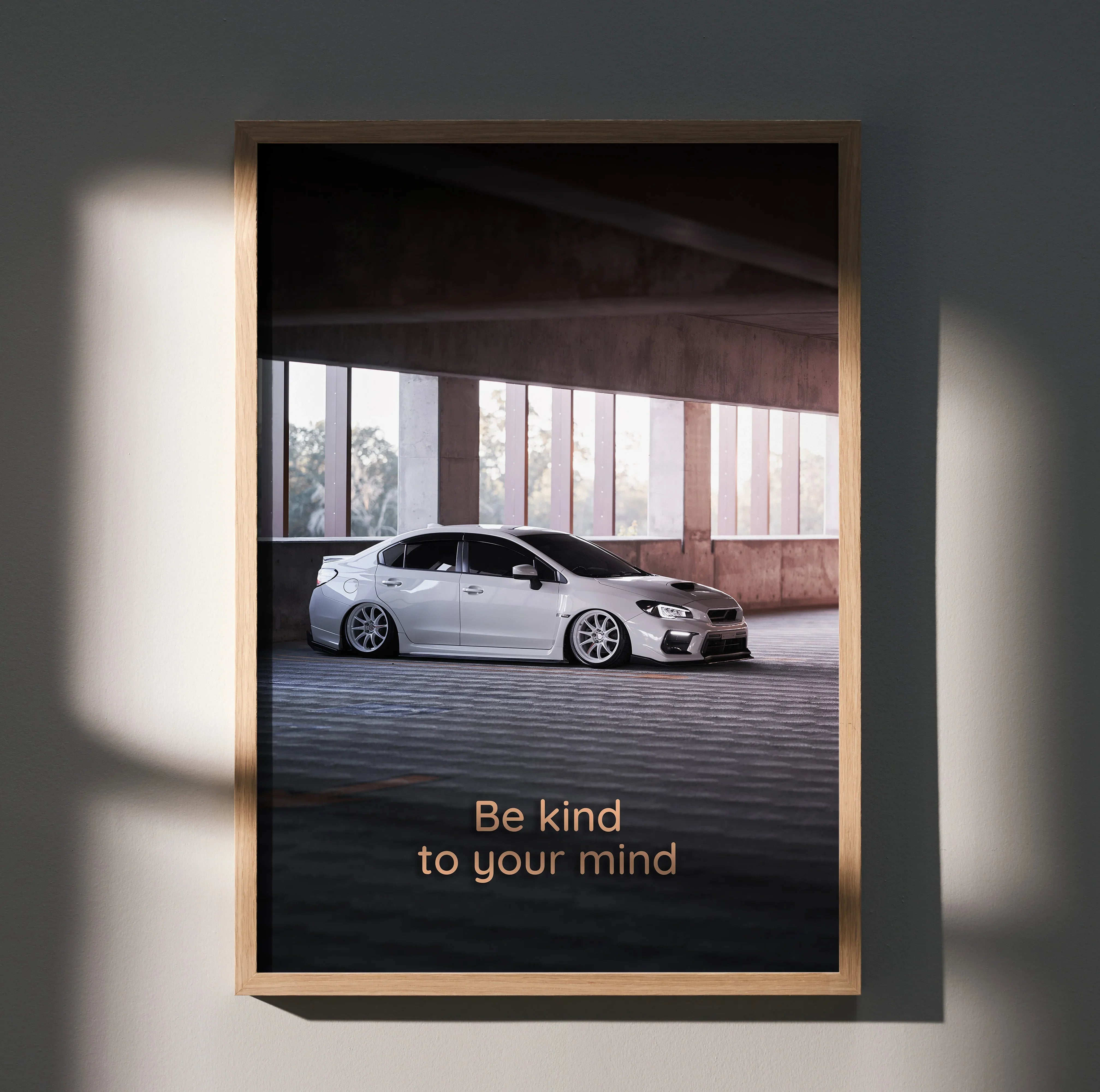 Subaru WRX parked under concrete structure with "Be kind to your mind" motivational text poster wall art.