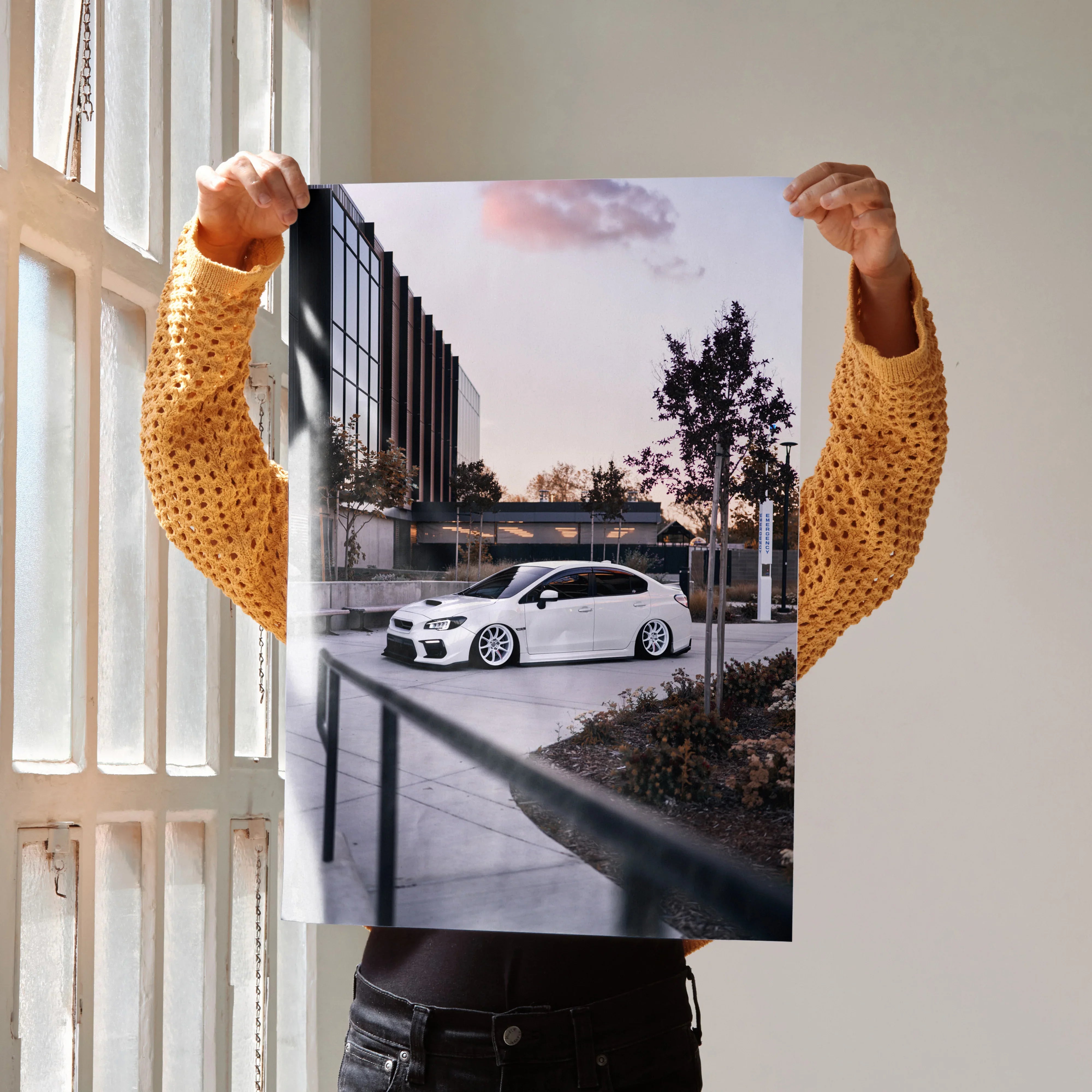 Subaru WRX poster featuring a white car parked by urban buildings at sunset, wall art for car lovers.