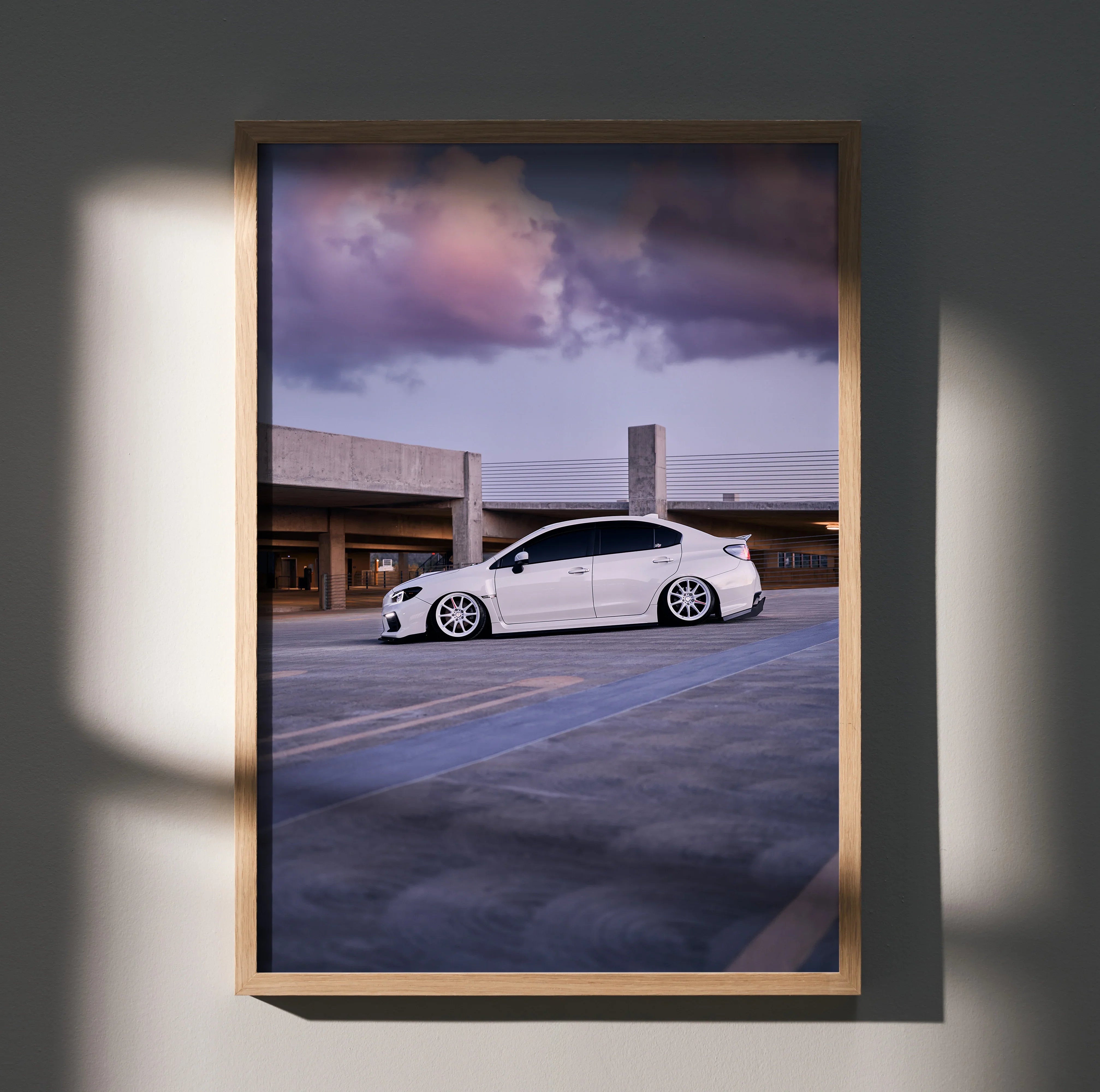 Subaru WRX white sports car against dramatic sunset sky poster wall art in wooden frame.
