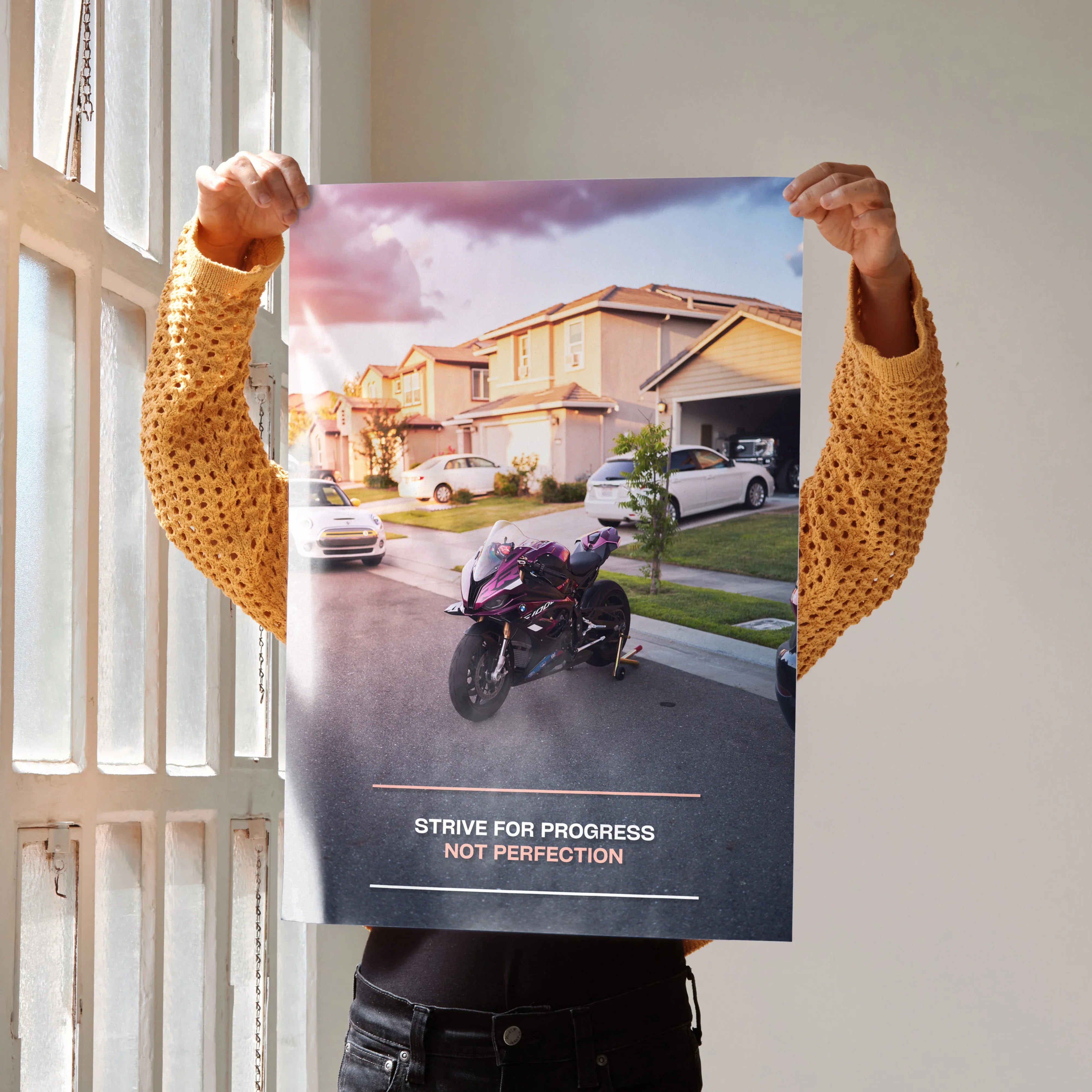Motivational poster wall art featuring a BMW S1000RR motorcycle with inspiring text in a suburban street setting.