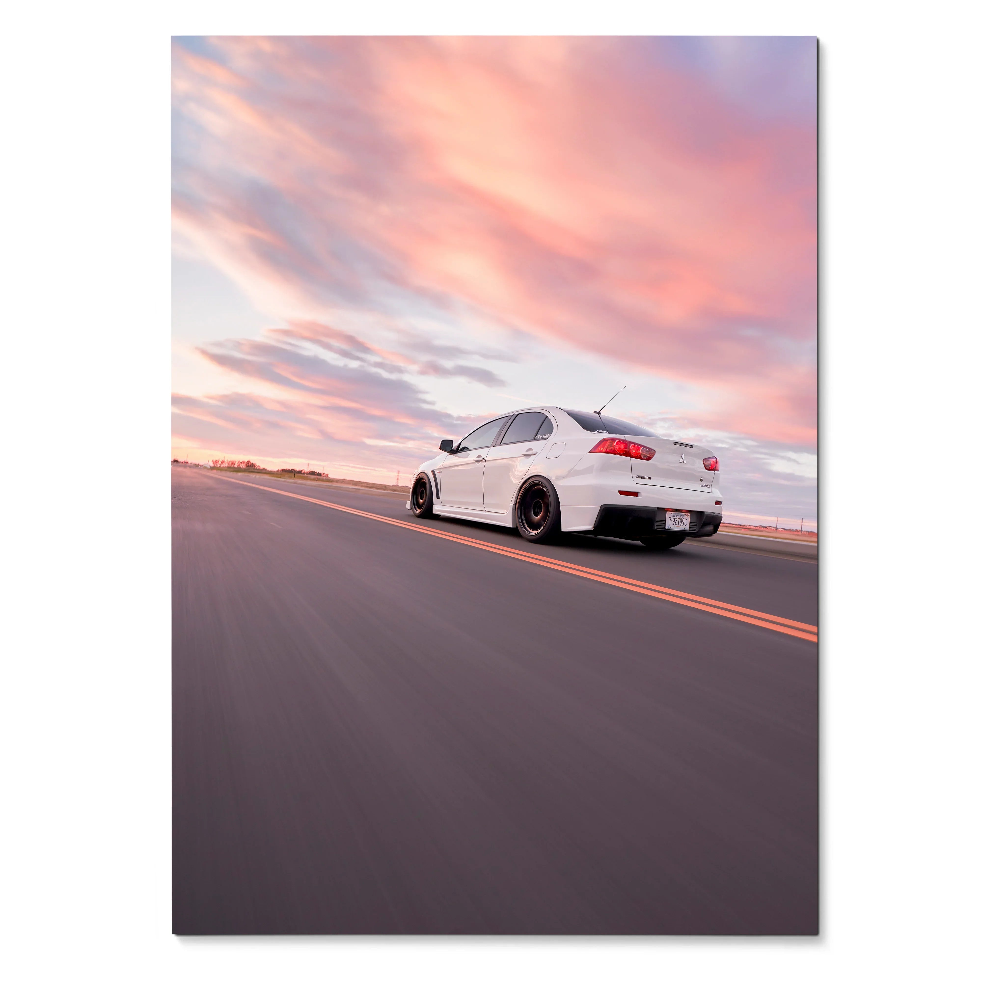 Mitsubishi Evo 10 poster with white car on open road under vibrant pink and orange sunset sky wall art.
