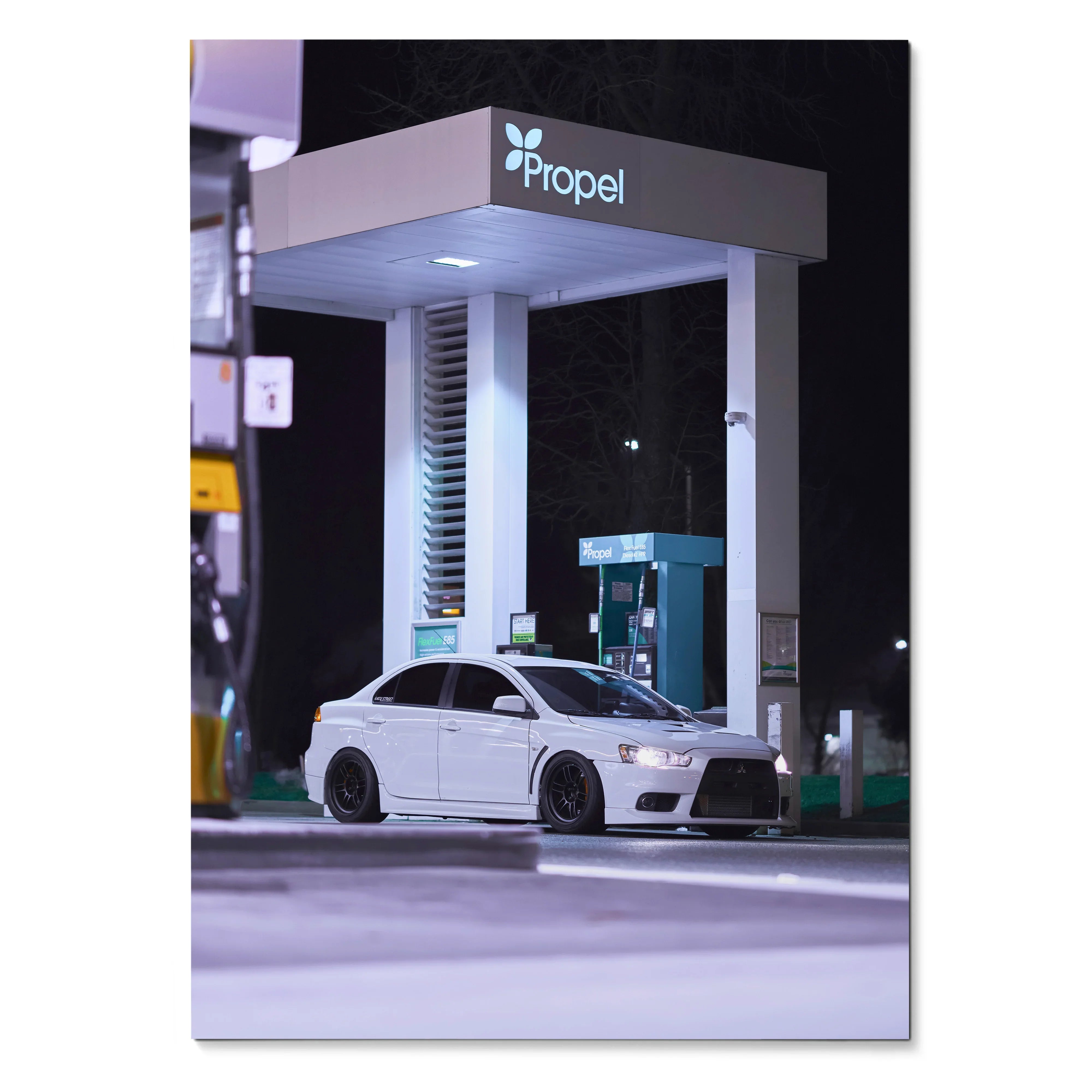 Mitsubishi Evo 10 white sports car parked at illuminated night gas station poster wall art.