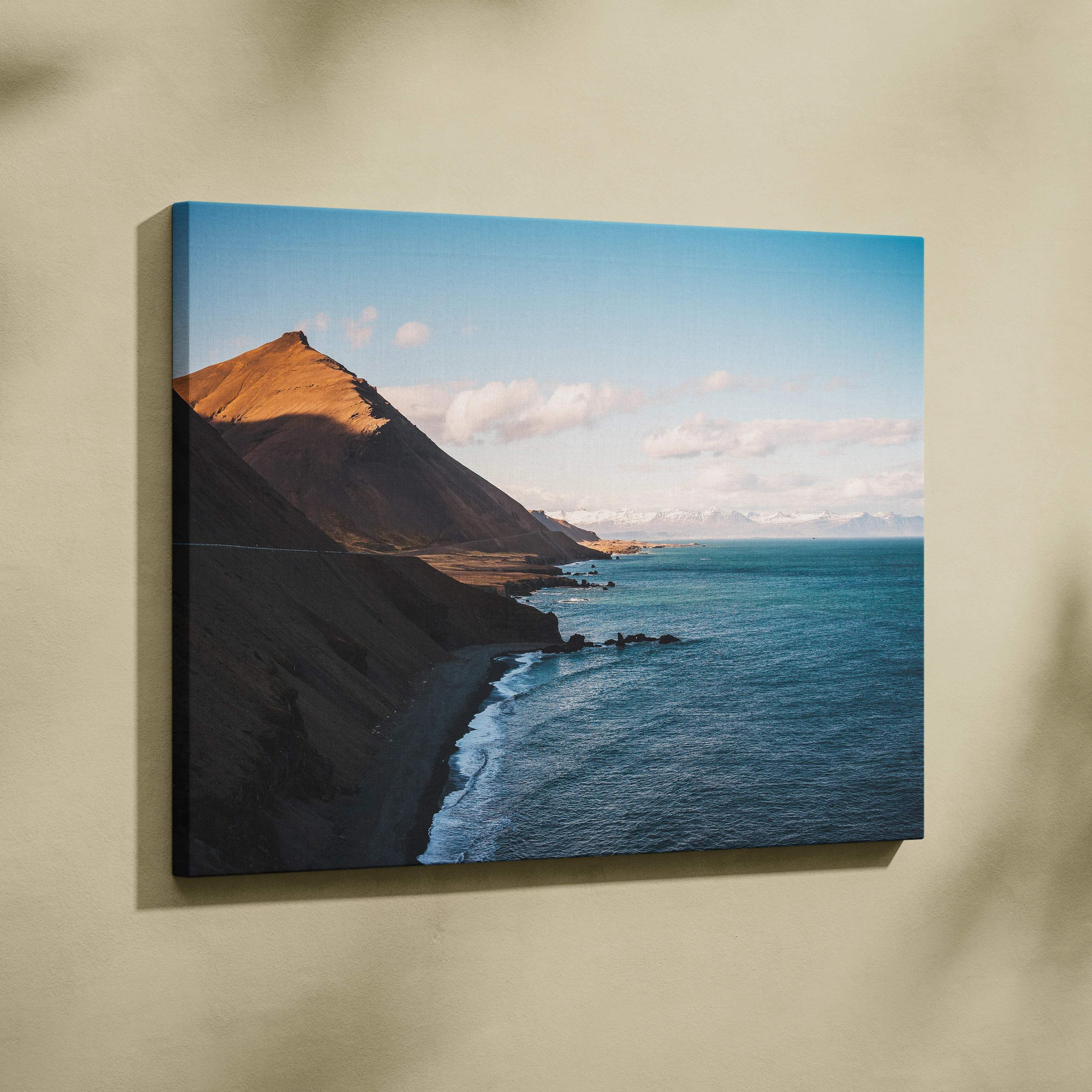 Canvas print of Iceland coastline with sunlit cliffs and blue ocean waves