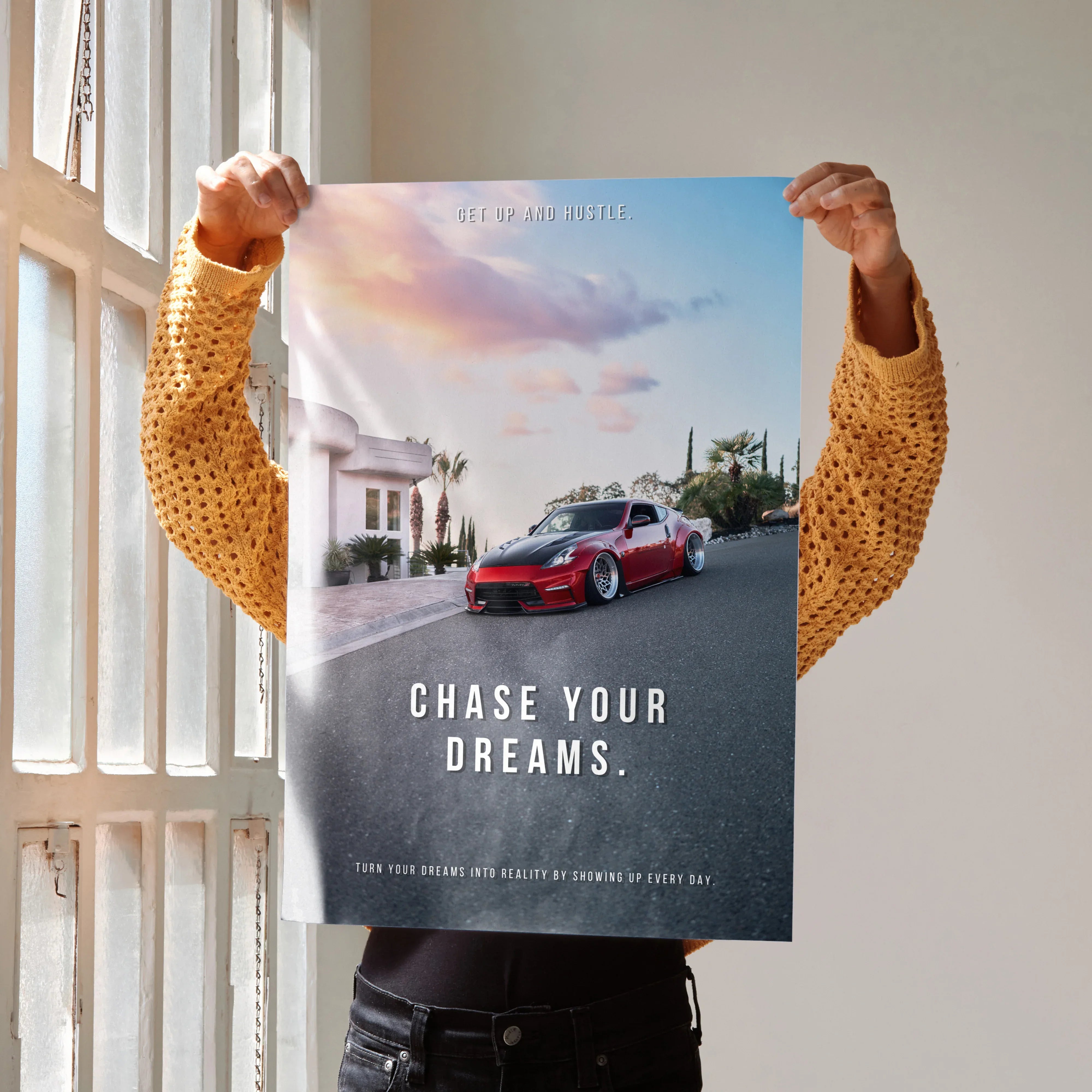 Motivational wall art poster featuring red Nissan 370z on scenic road with "Chase Your Dreams" text.