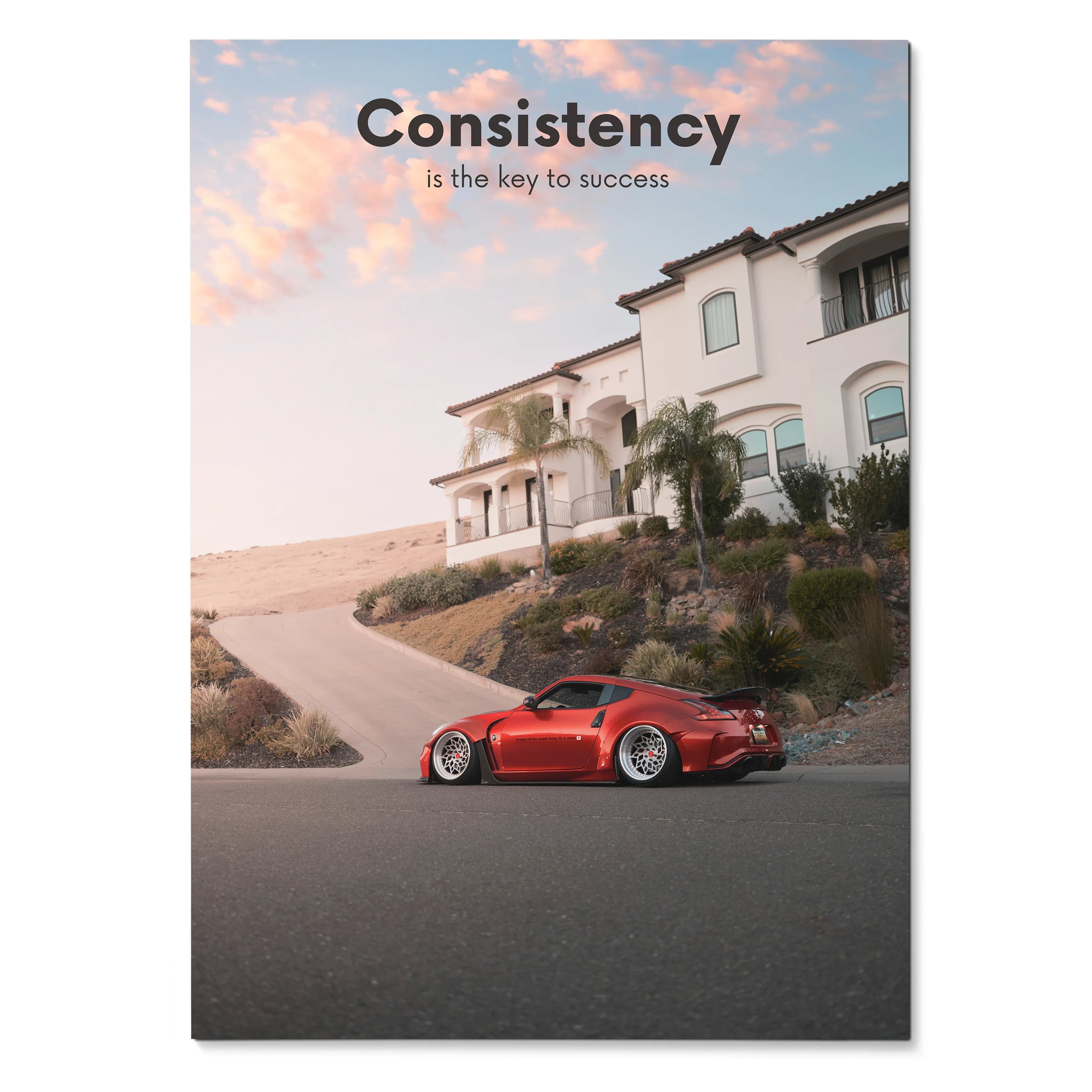 Poster wall art featuring a red Nissan 370z parked on a residential street under a pink sky with the text "Consistency is.