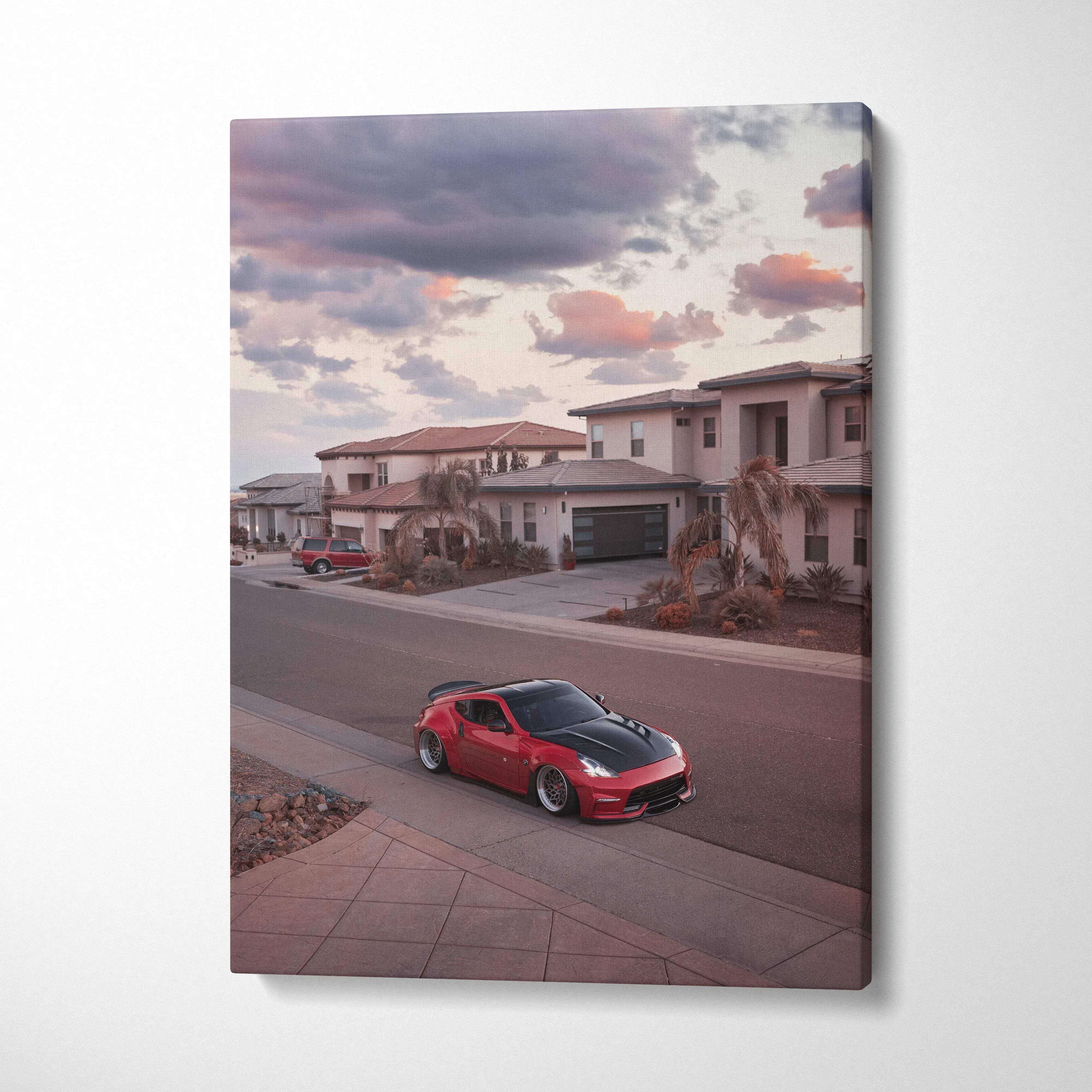 Red Nissan 370z parked on suburban street at sunset on vertical canvas wall art.