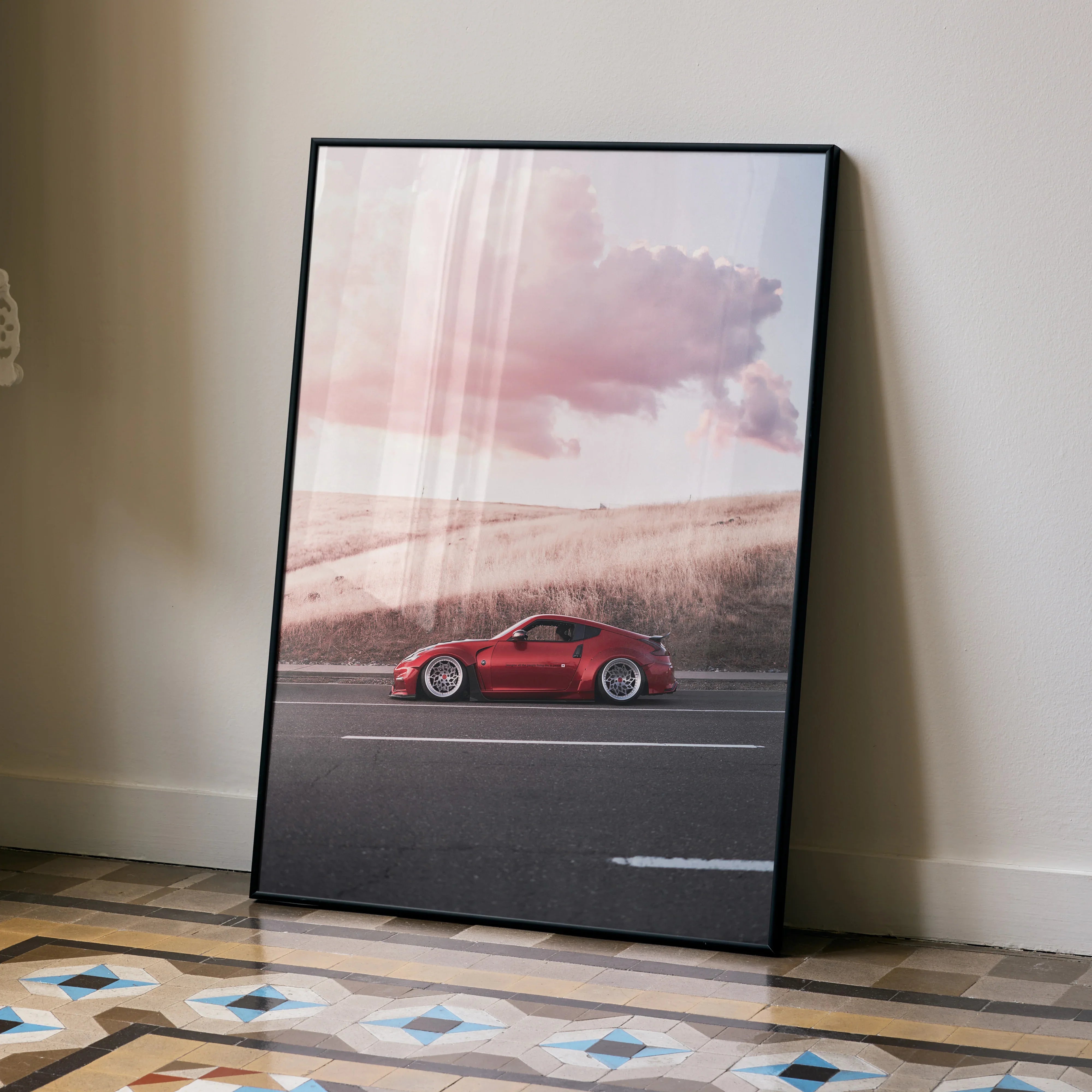 Nissan 370z poster with red sports car against a sunset sky, high-resolution wall art in black frame.