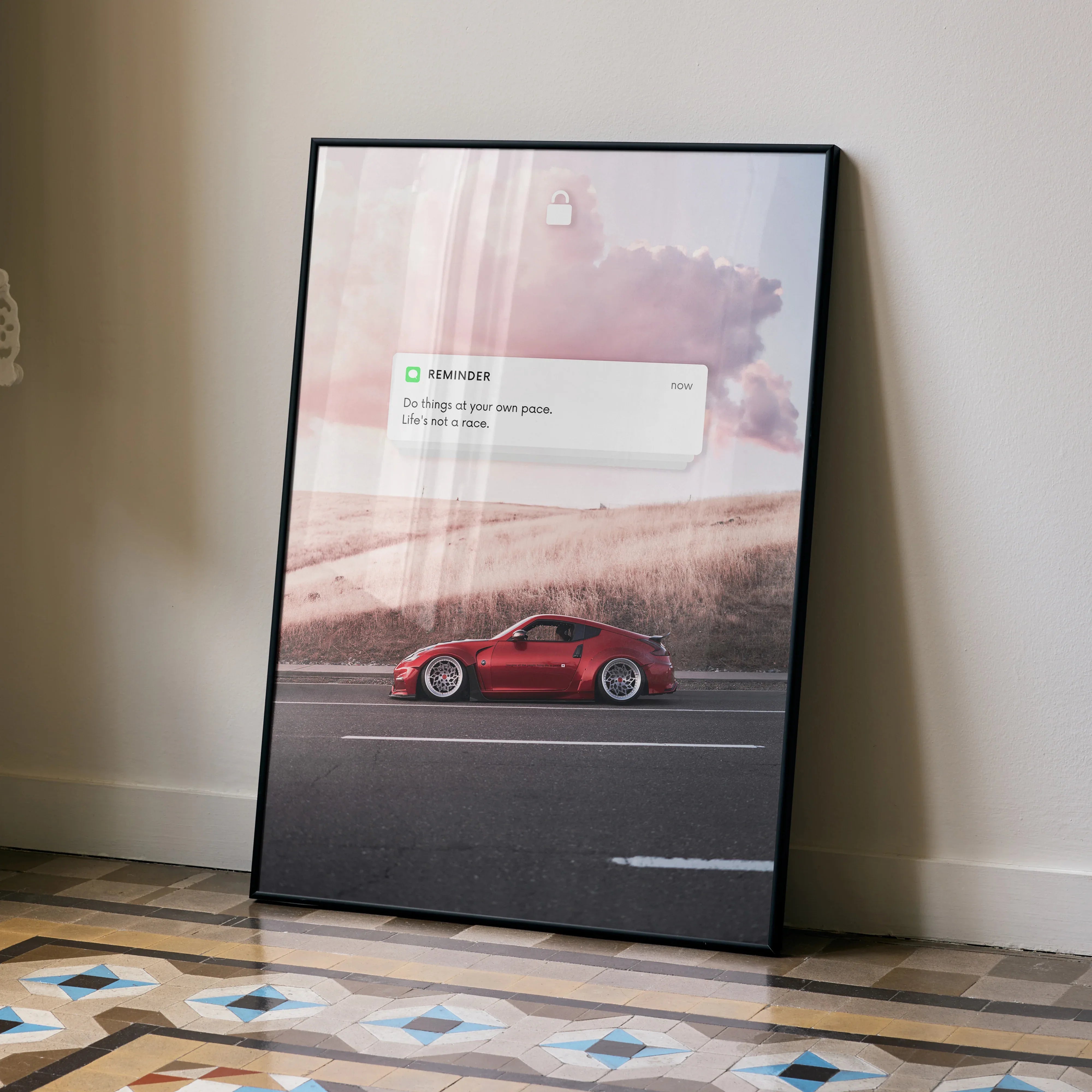 Motivational poster wall art featuring a red Nissan 370Z driving along a road under a cloudy sky.