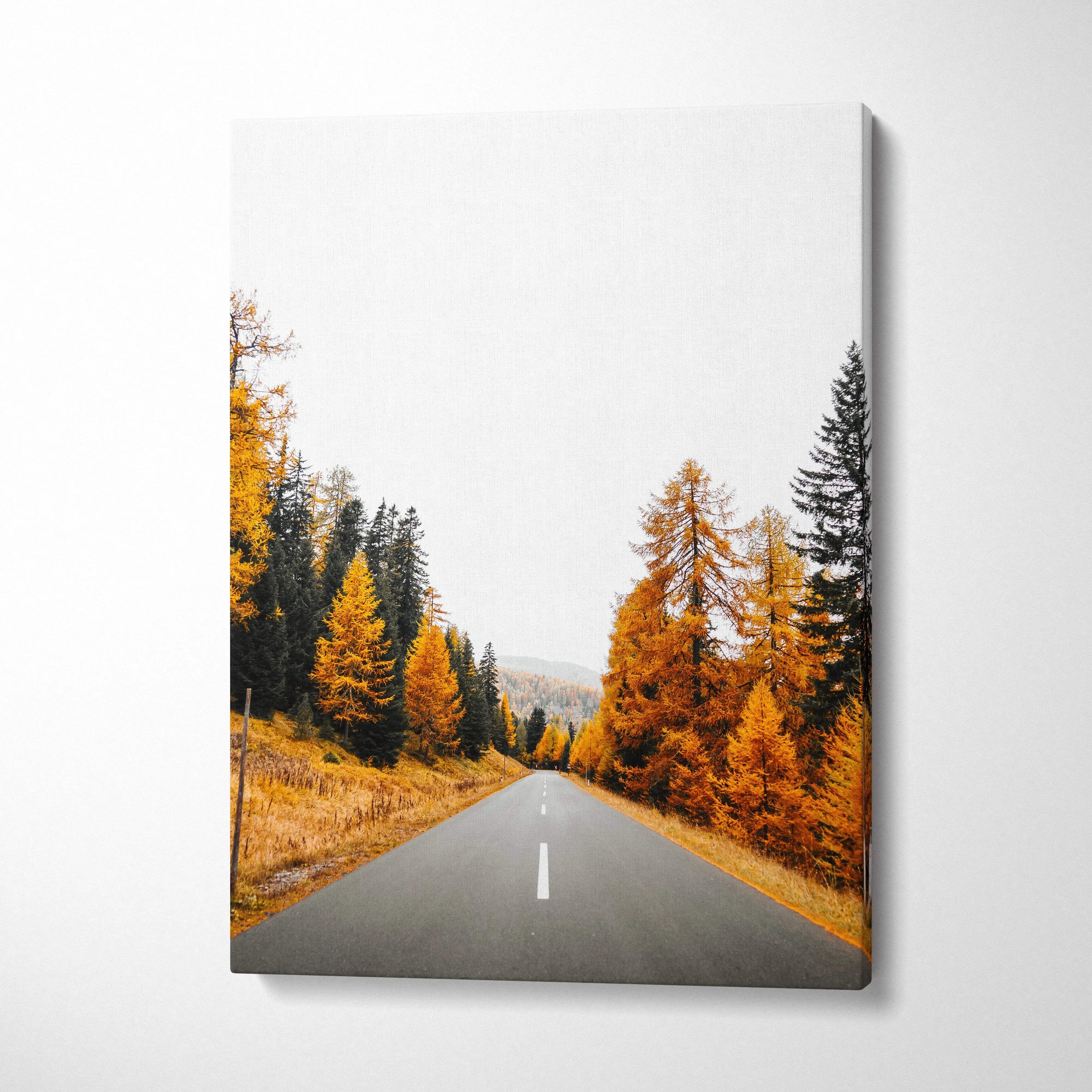 Vertical canvas art featuring a vibrant autumn landscape with golden trees lining a straight road; wall art print.