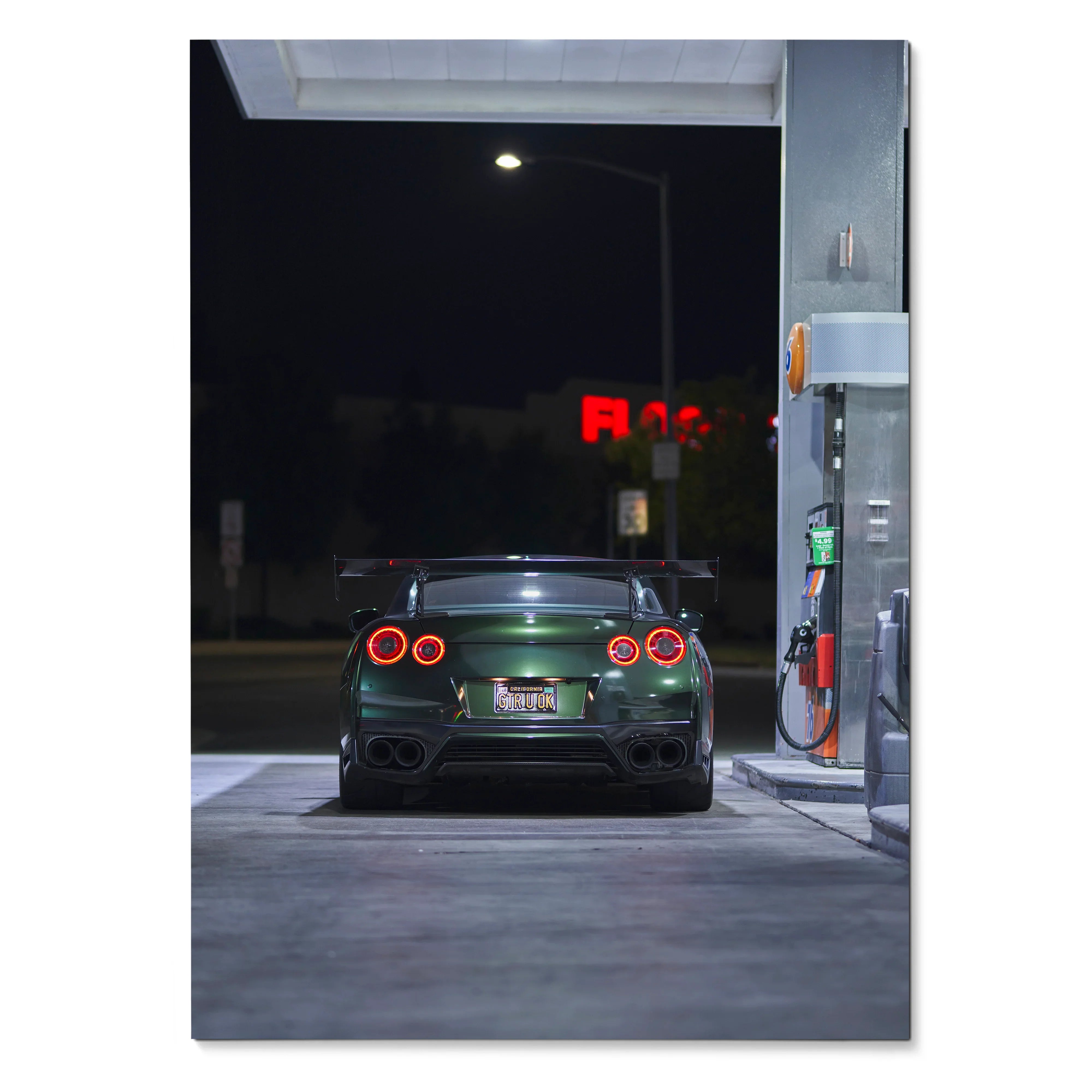 Nissan GTR R35 rear view at night gas station poster wall art in dark green color.