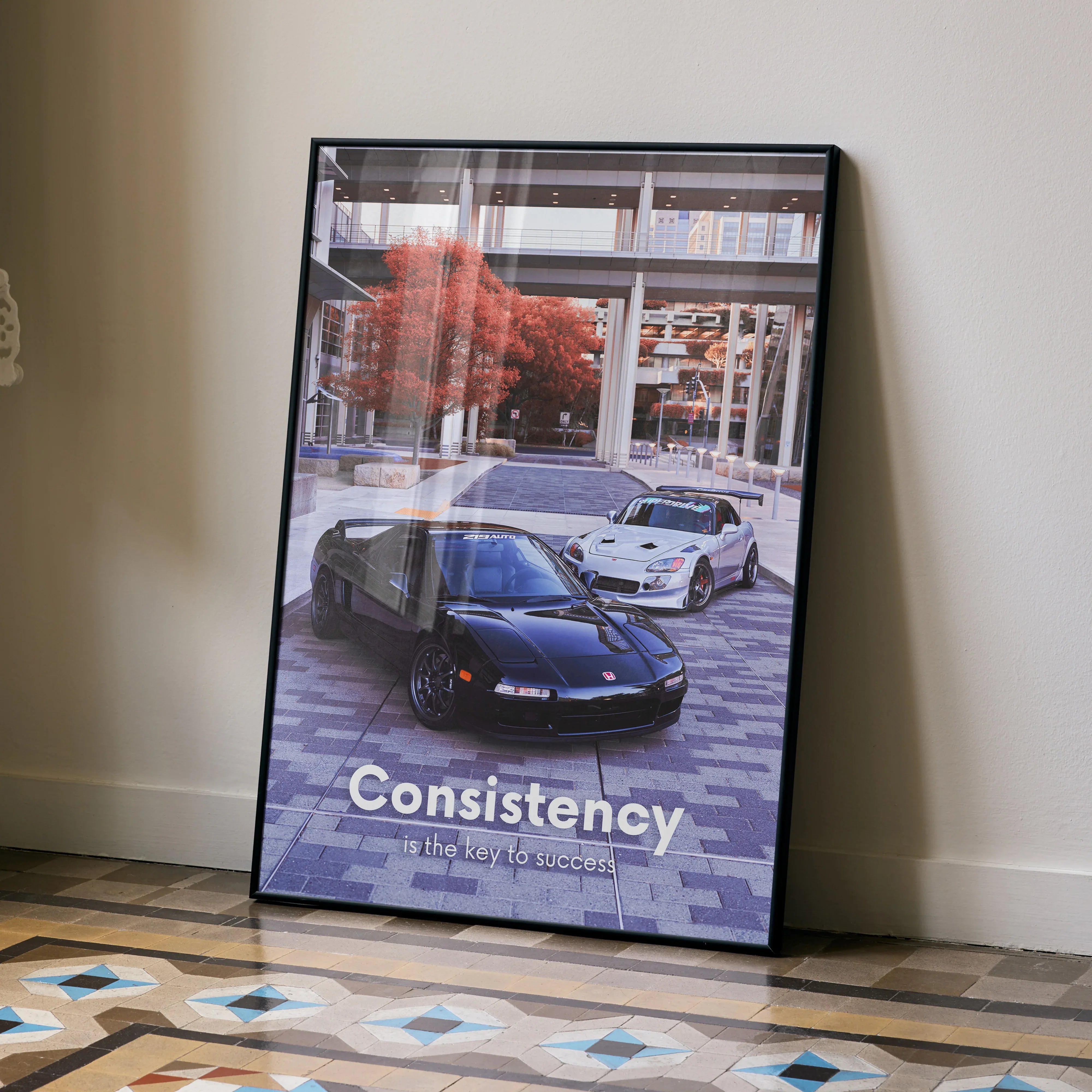 Motivational poster wall art featuring Acura NSX and Honda S2000 with "Consistency" text in urban setting.
