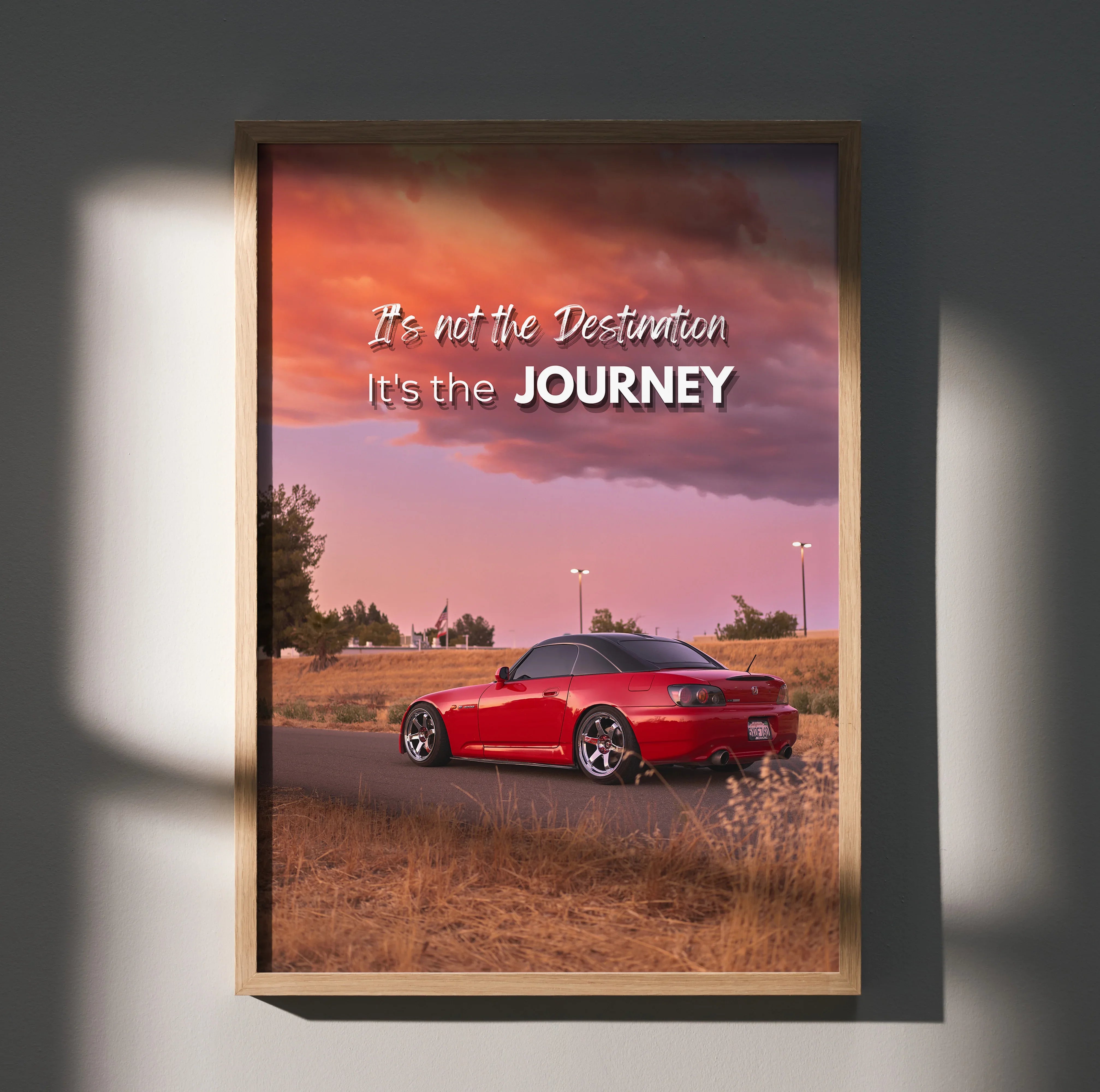 Motivational poster wall art with red Honda S2000 under a colorful sunset sky and inspiring text.